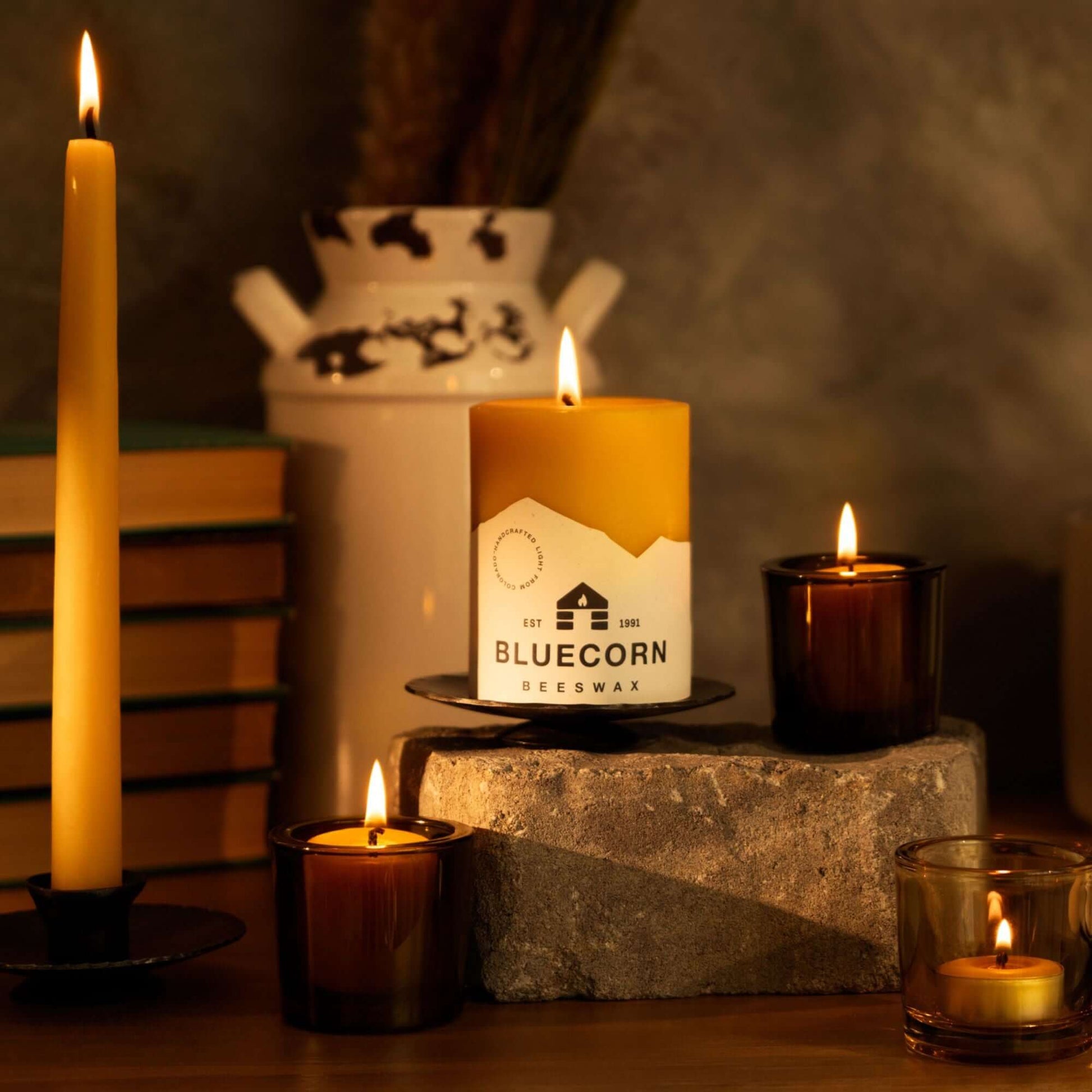 Pair of hand-dipped beeswax taper candles from Bluecorn Candles, with additional votives and tea lights in glass, ideal for fall decor.