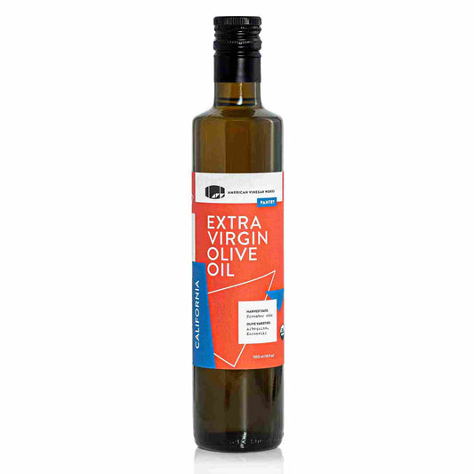 Bottle of California organic extra virgin olive oil from American Vinegar Works, with a label featuring olive branches and a gold cap.