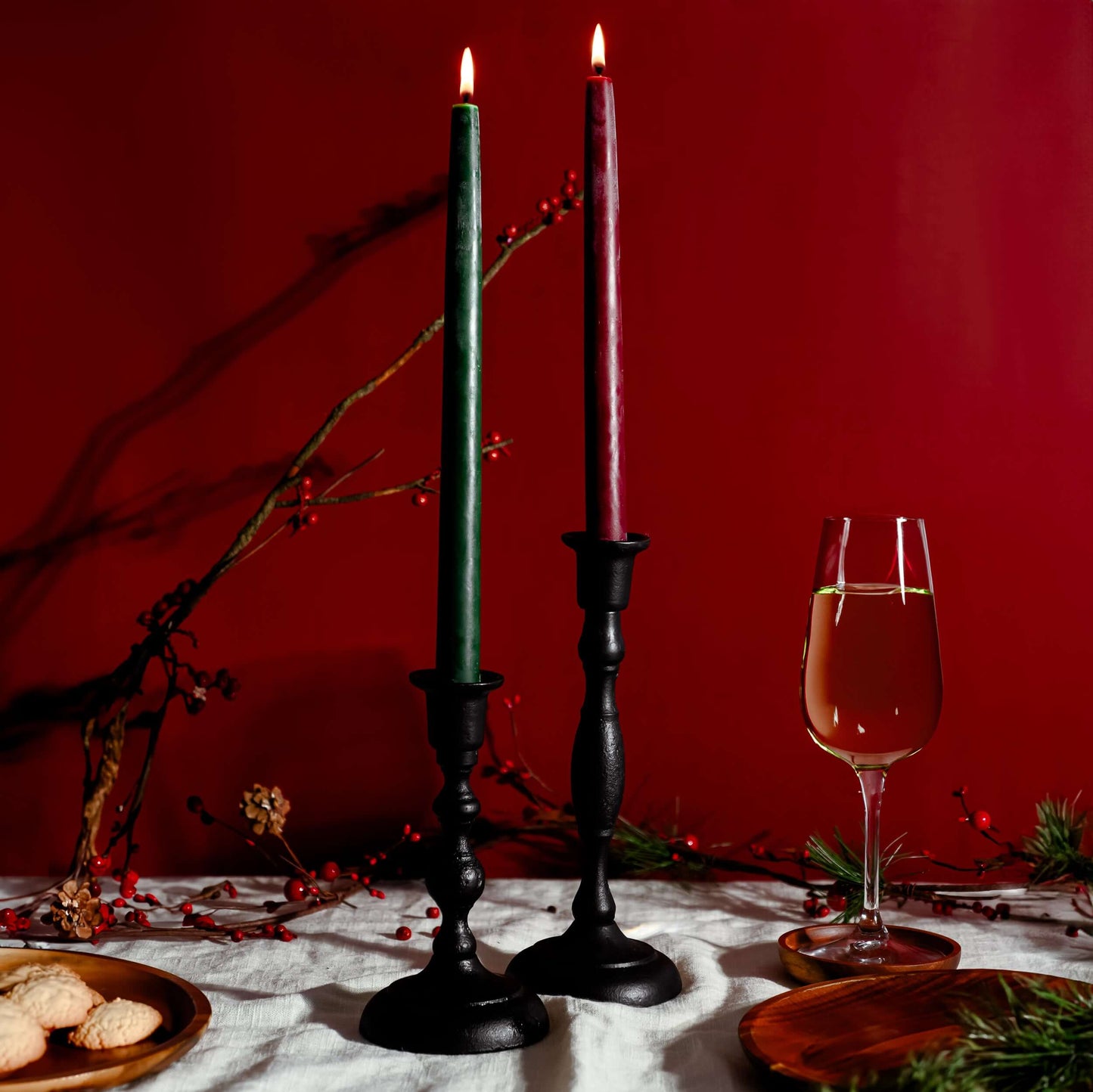 Handcrafted cast iron taper candle holders on a Christmas table, featuring tall taper candles for festive decor.