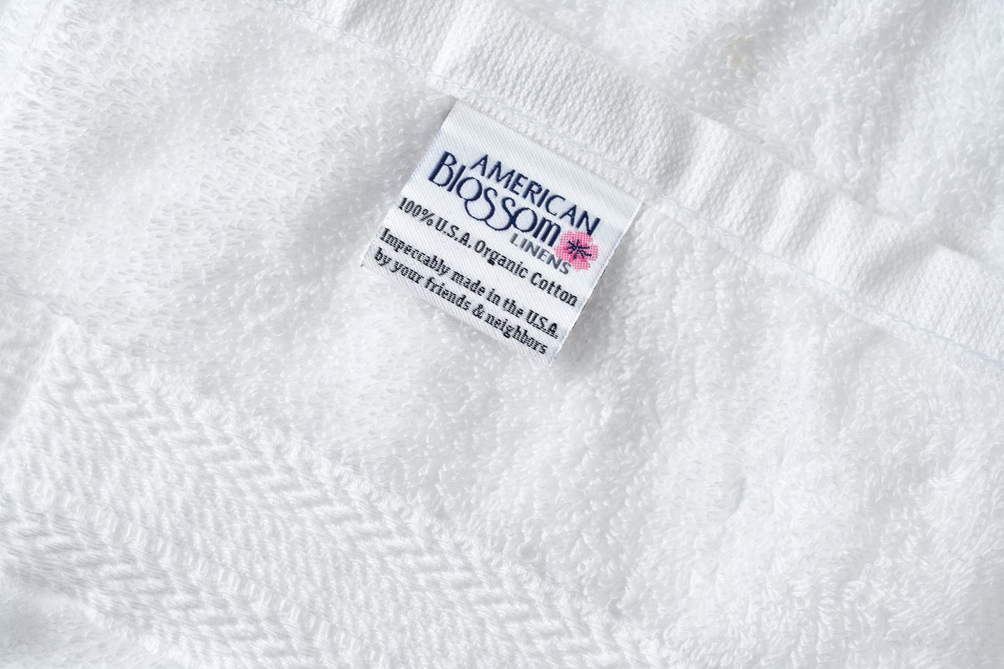 Closeup of white luxury USA cotton bath washcloths by American Blossom Linens showing soft, natural fabric texture.