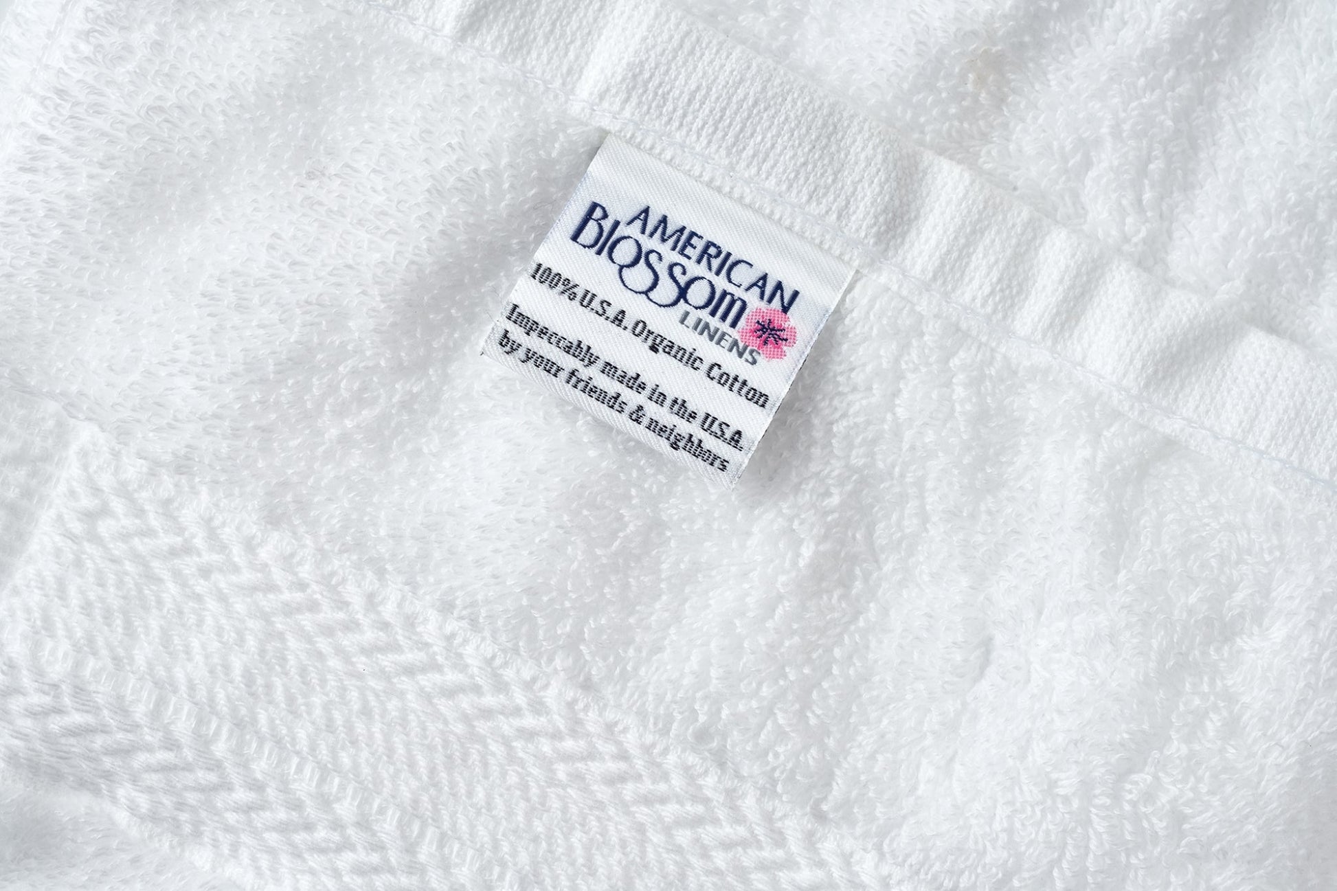 Closeup of white luxury USA cotton bath washcloths by American Blossom Linens showing soft, natural fabric texture.