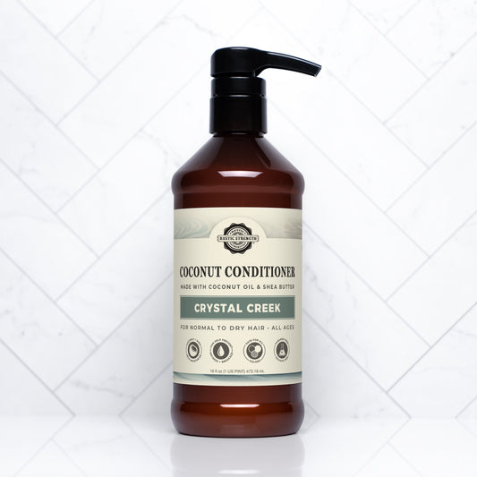 Rustic Strength Coconut Conditioner in a 16 oz bottle, featuring a creamy texture and tropical coconut scent for smooth, healthy hair.