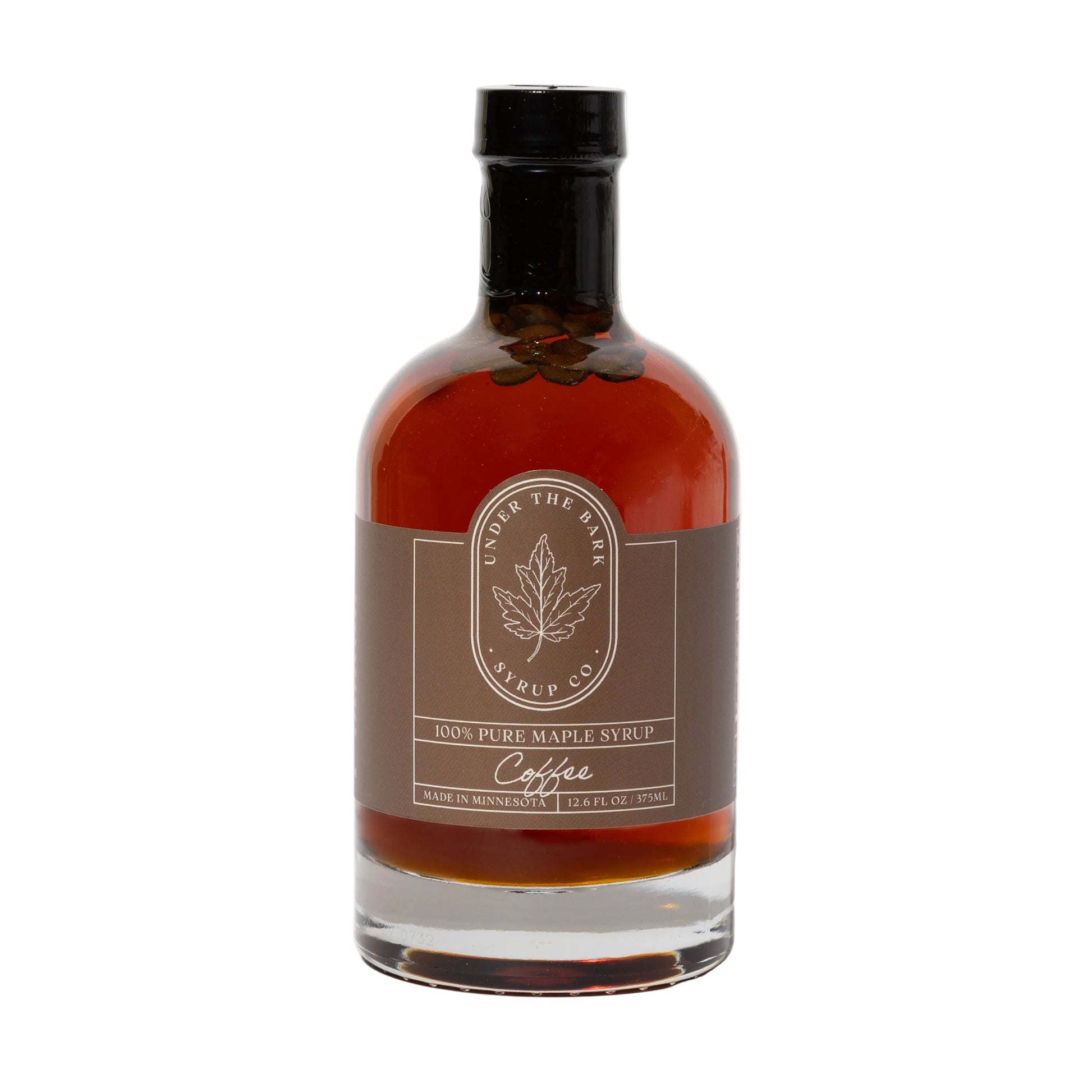 12oz bottle of Under The Bark Syrup Co Coffee Maple Syrup, rich and sweet with coffee and maple flavors, in a clear glass bottle.
