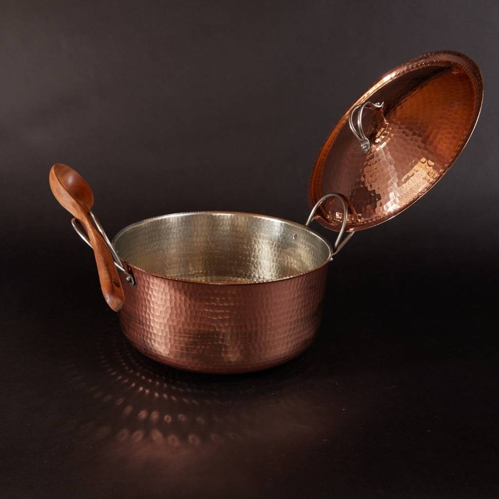 Large copper Dutch oven by Sertodo with lid and ladle, showcasing polished copper surface and sturdy handles.