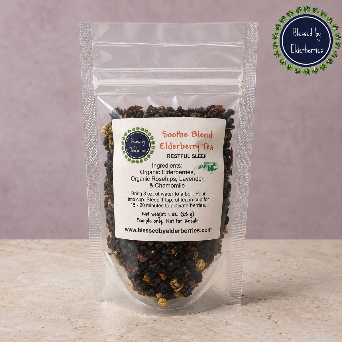 Blessed by Elderberries Soothe Blend Elderberry Tea in a clear glass mug with tea leaves and elderberries visible.