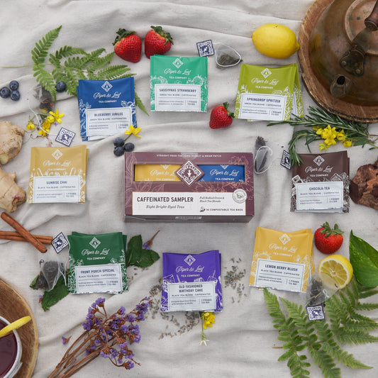 Assorted Piper and Leaf Tea Co. caffeinated tea bags in a tasting flight box with 12 individual tea bags on a white background.
