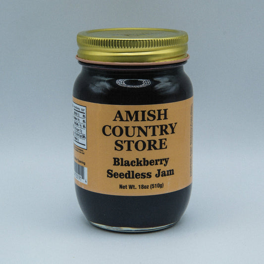 Cans of Amish Country Store Blackberry Seedless Jam in 18 oz jars, featuring a label with fresh blackberries and product details.