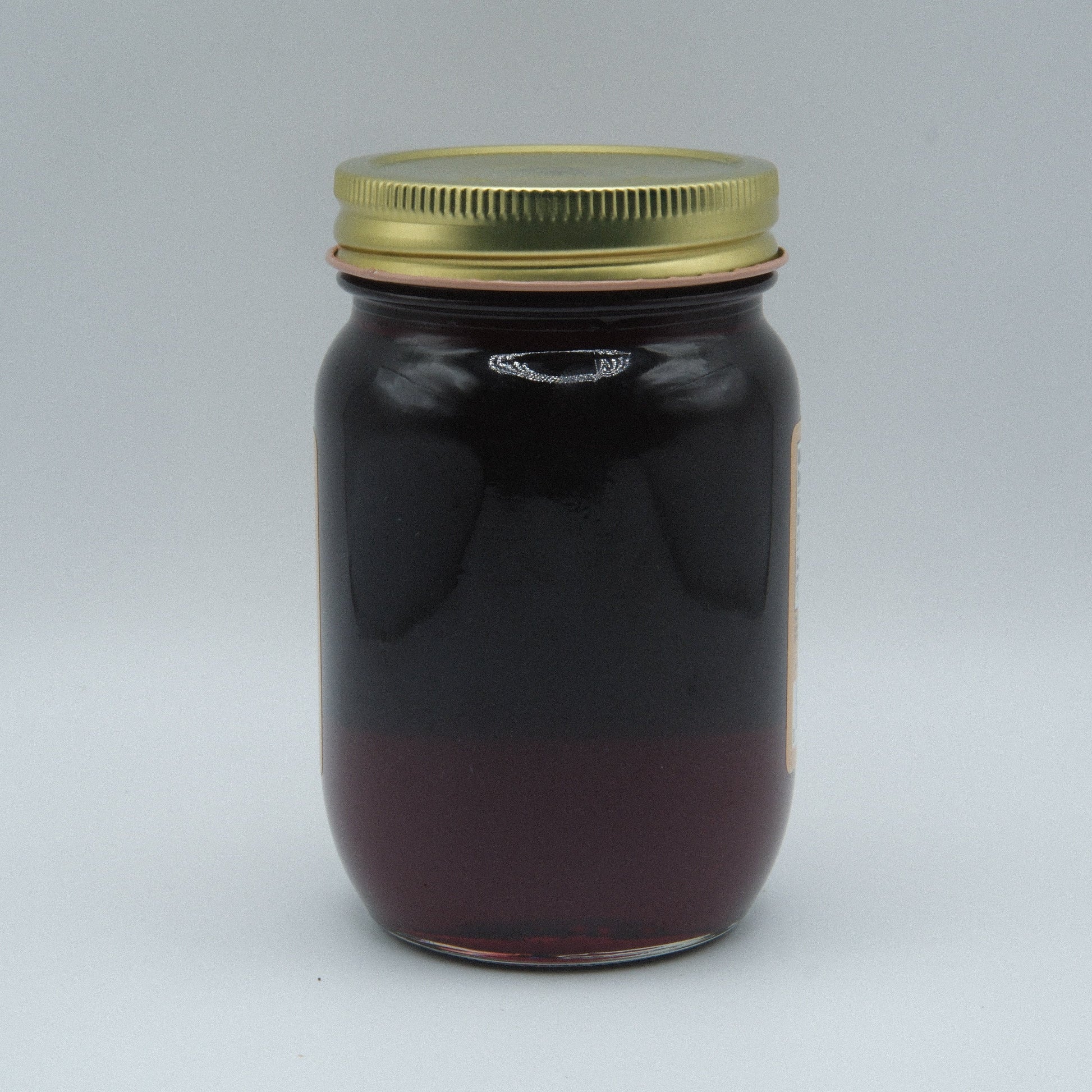 Canned Amish Country Store Concord Grape Jelly in an 18 oz jar, showcasing the jar with purple grape jelly inside.