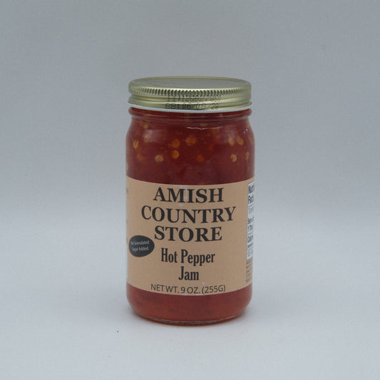 Canned Amish Country Store Hot Pepper Jam with no sugar added in a 9 oz jar, showing vibrant red peppers and jam inside.