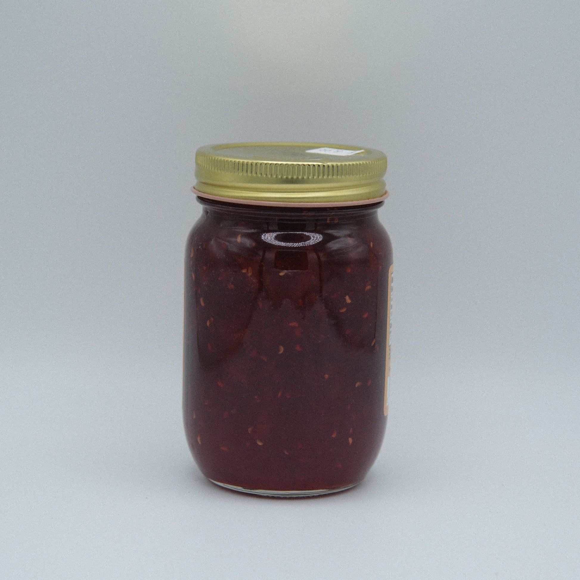 Canned Amish Country Store Traffic Jam in 18oz jar, showing the label and jam inside the glass jar for natural fruit spread.