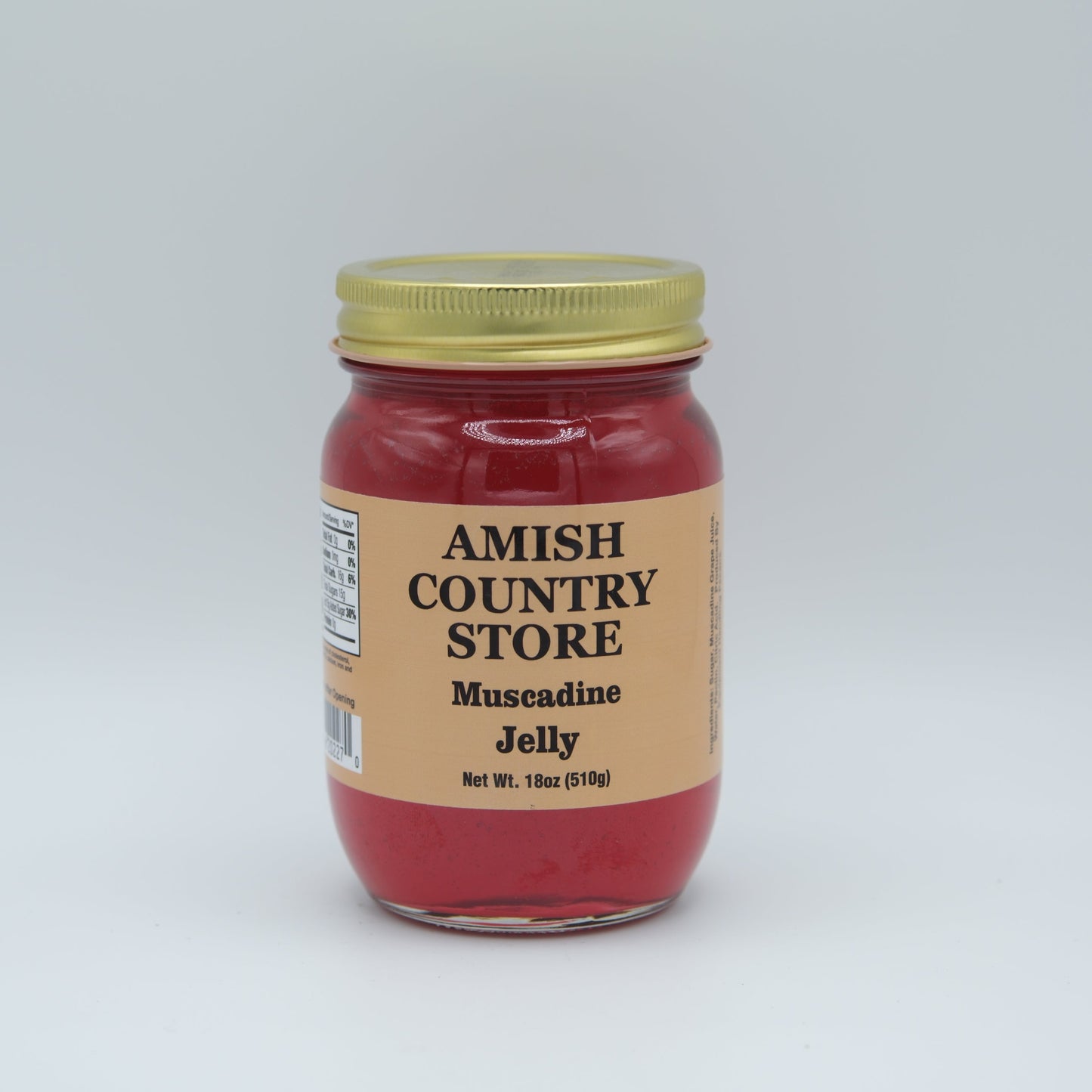 Canned Muscadine Jelly 18oz jar from Amish Country Store, smooth purple jelly with a gold lid sitting on a wooden surface.