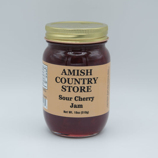 Canned Amish Country Store sour cherry jam jar with label, showcasing bright red cherries and jam texture.