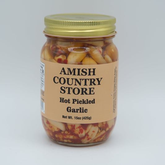 Canned hot pickled garlic from Amish Country Store in a 15oz jar, showing garlic cloves immersed in spicy pickling brine.