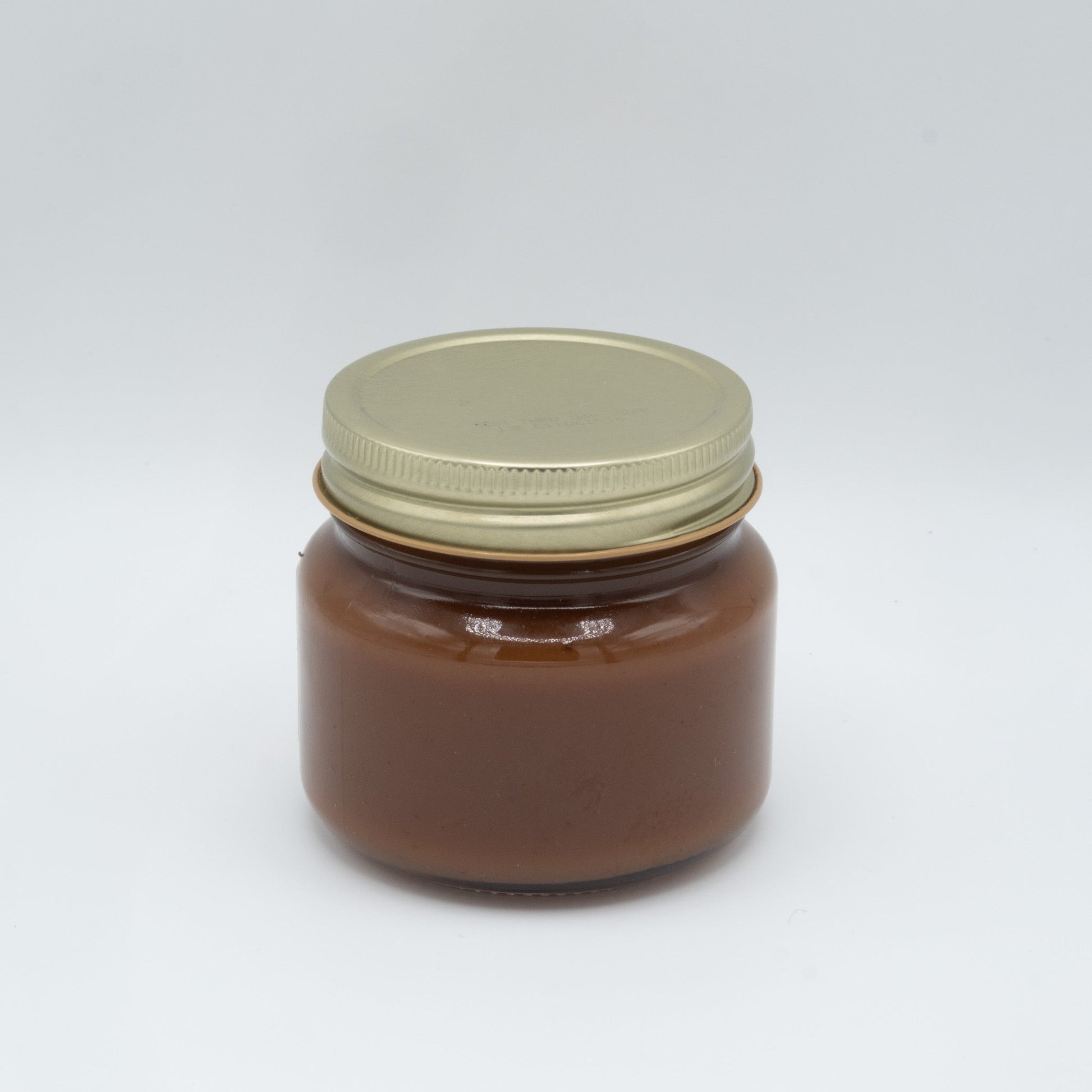 Canned apple butter from Amish Country Store with a smooth, dark spread inside a jar, ready for use in recipes or on toast.