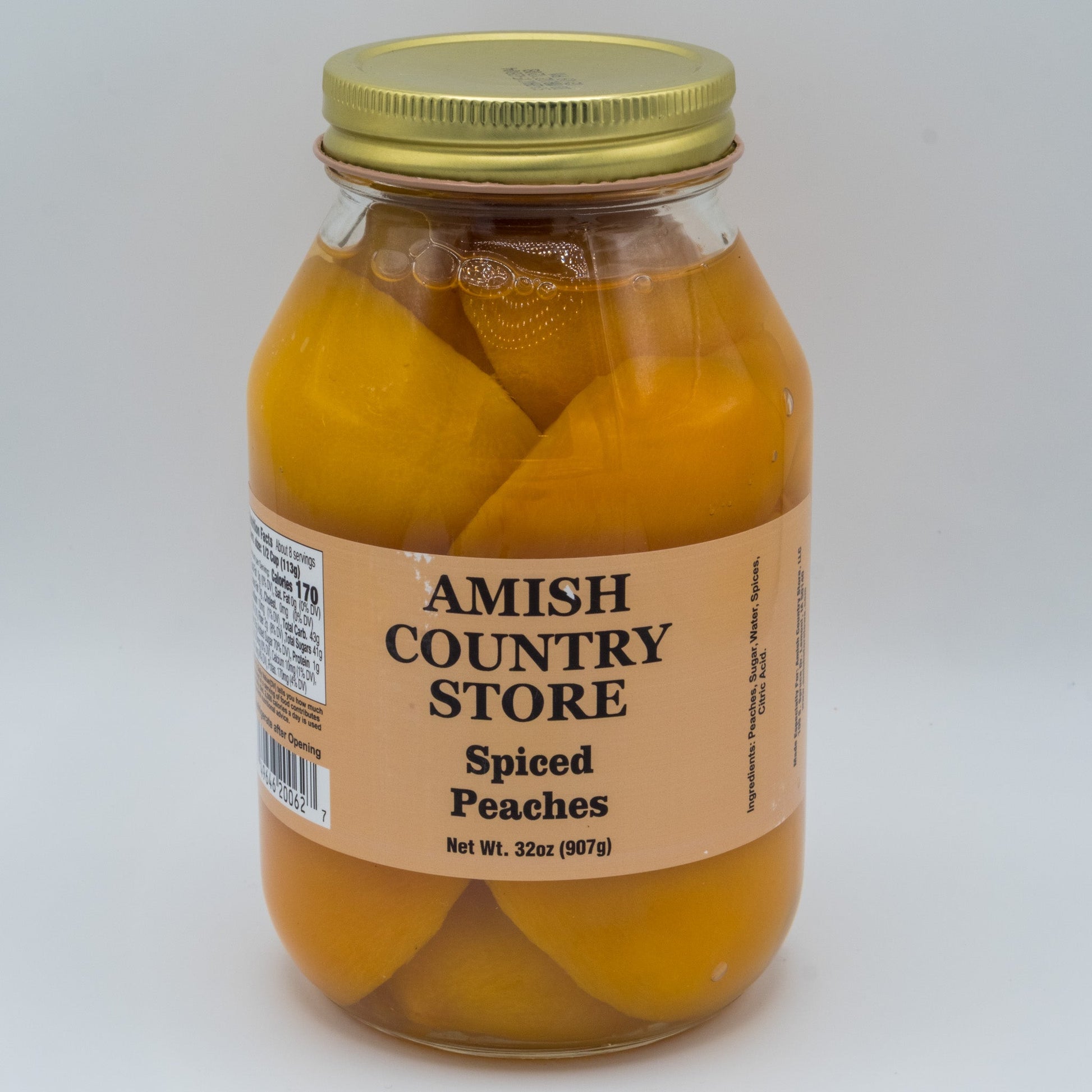 Canned Spiced Peaches in a 32oz jar from Amish Country Store, showcasing ripe peaches with spiced syrup in a glass jar.
