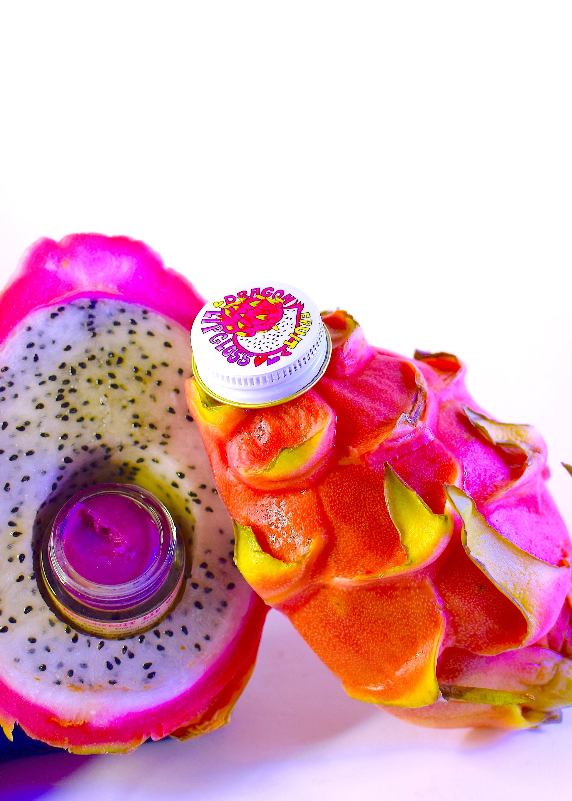 Dragon Fruit Lip Gloss by Plant Makeup, close-up of glossy pink lip gloss tube with dragon fruit flavor label.