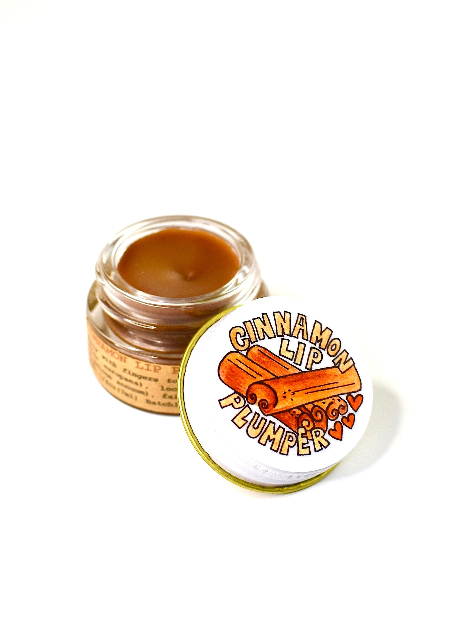 Plant Makeup Cinnamon Lip Plumper in a sleek tube, showcasing its warm cinnamon shade and smooth, glossy finish.