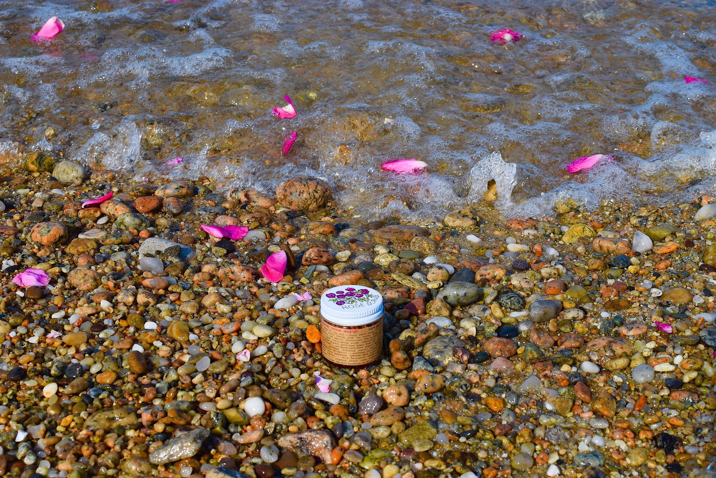 Plant Makeup Beach Rose Scrub jar with rose petal accents, showcasing natural skincare exfoliator in a clear container.