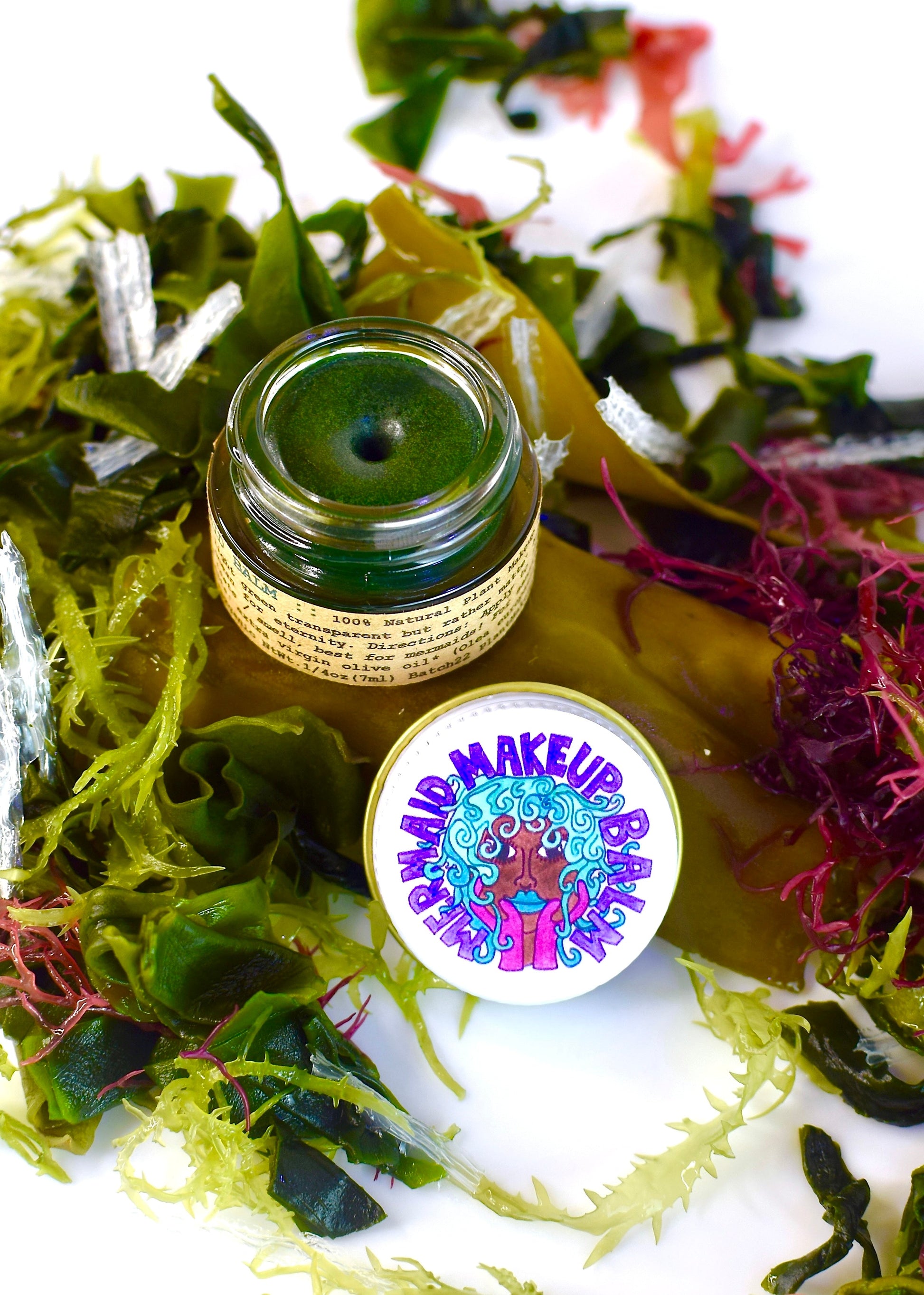 Plant Makeup Mermaid Makeup Balm in a jar with shimmery, turquoise-colored balm and mermaid-themed packaging.