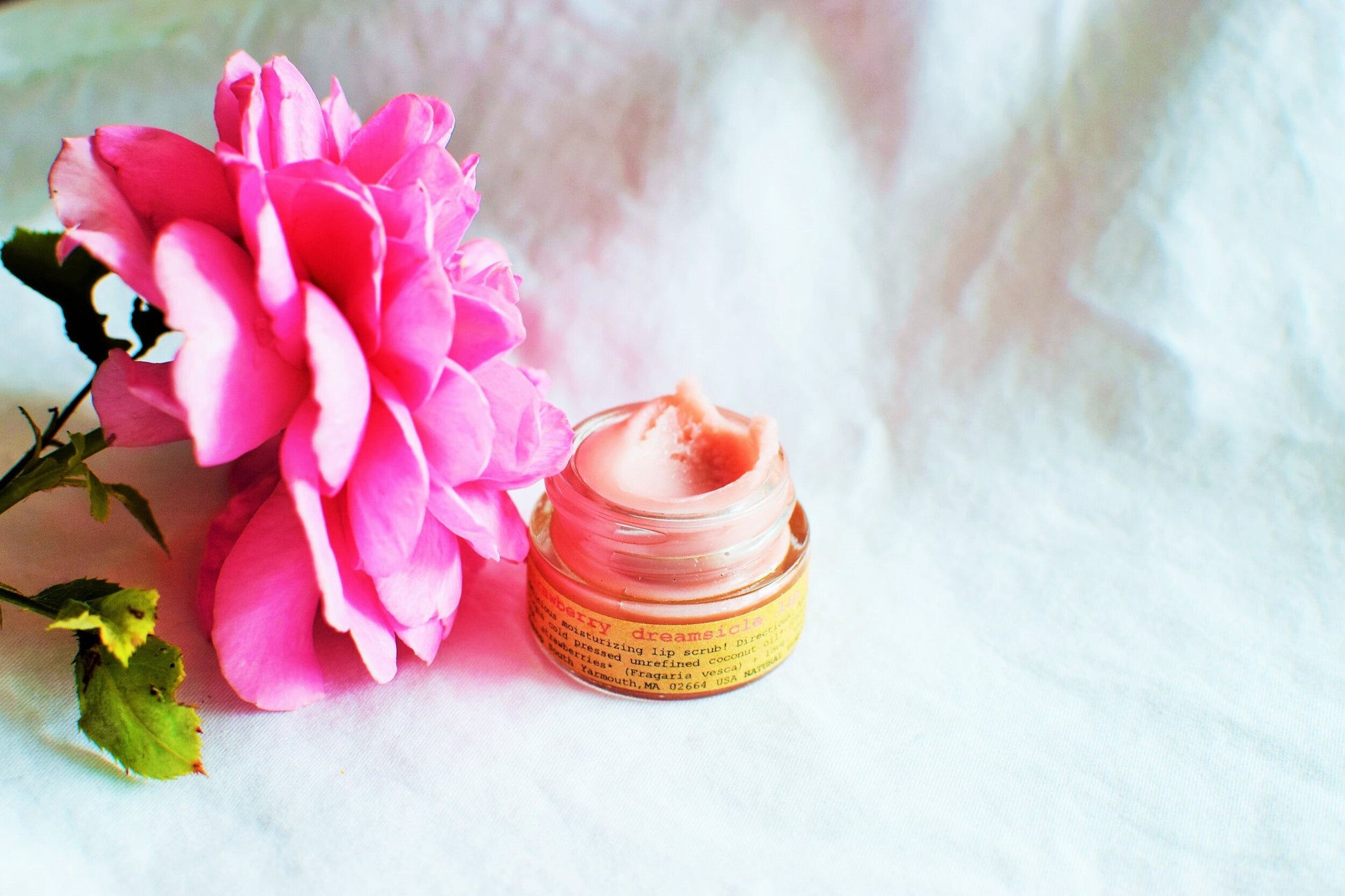 Plant Makeup Strawberry Dreamsicle Lip Balm Scrub in a jar, showcasing its creamy texture and fresh strawberry scent.