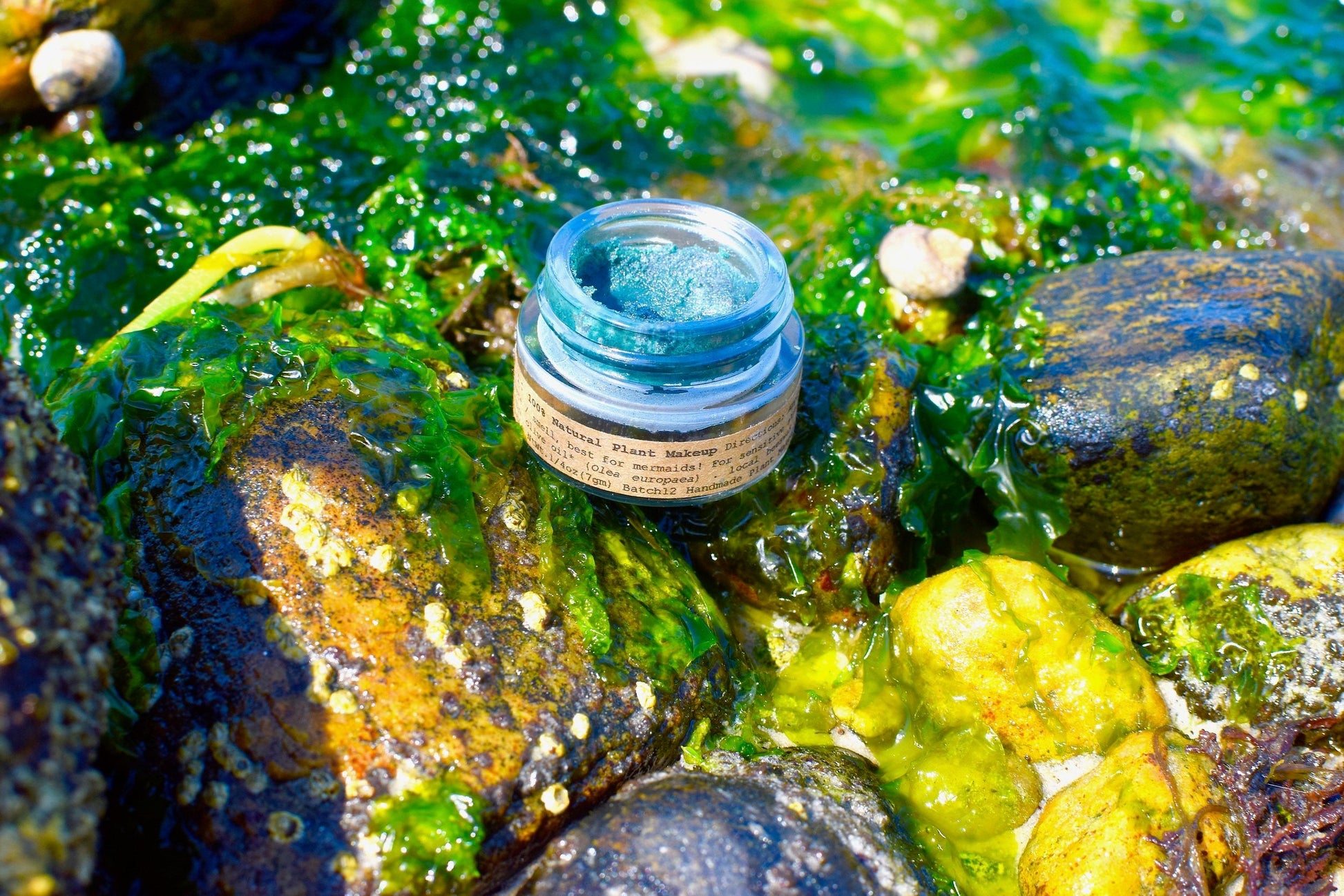 Close-up of Plant Makeup Mermaid Makeup Balm in a jar with shimmering, mermaid-inspired packaging and smooth, colorful balm inside.
