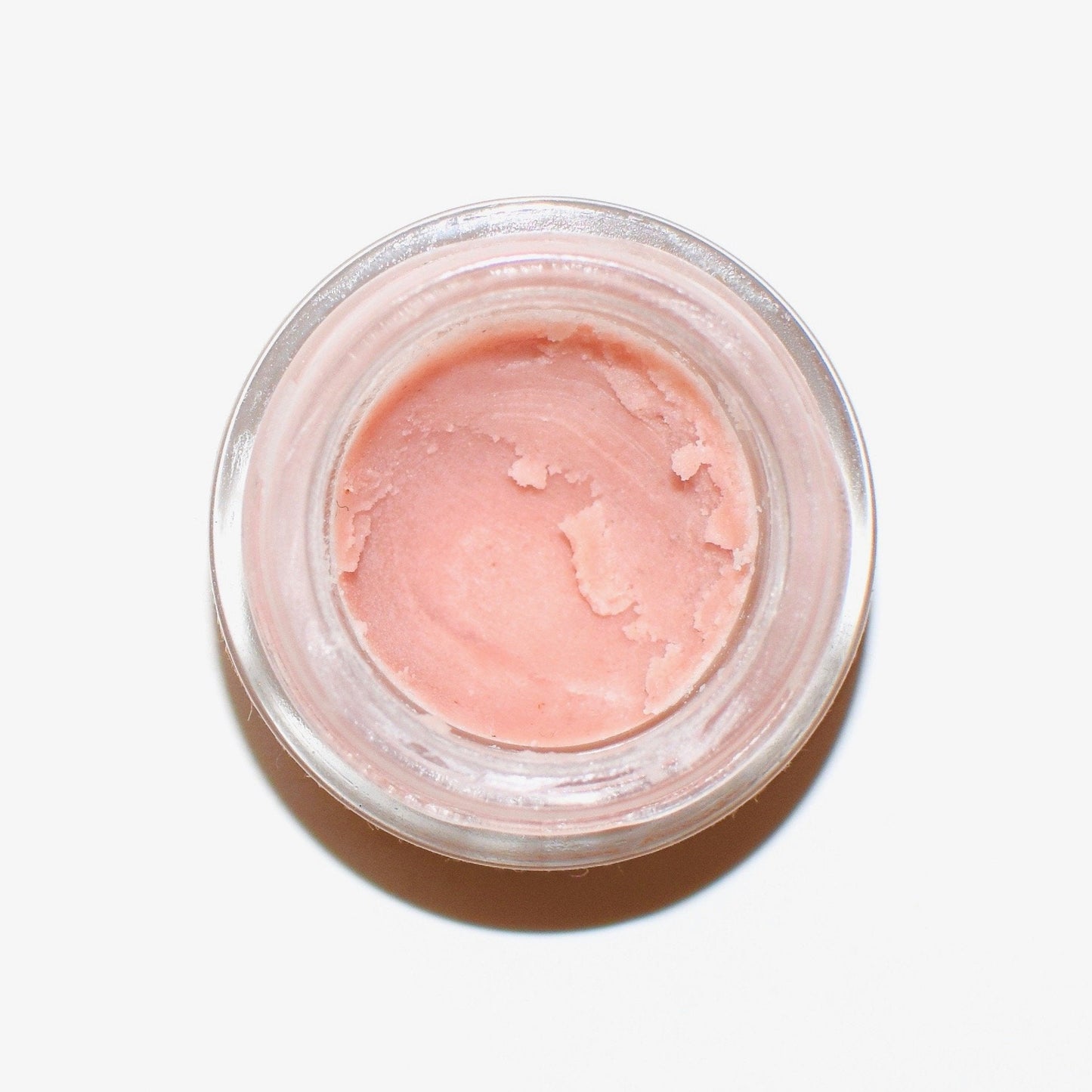 Plant Makeup Strawberry Dreamsicle Lip Balm Scrub in a clear jar with a pink and white creamy texture and fresh strawberry accents.