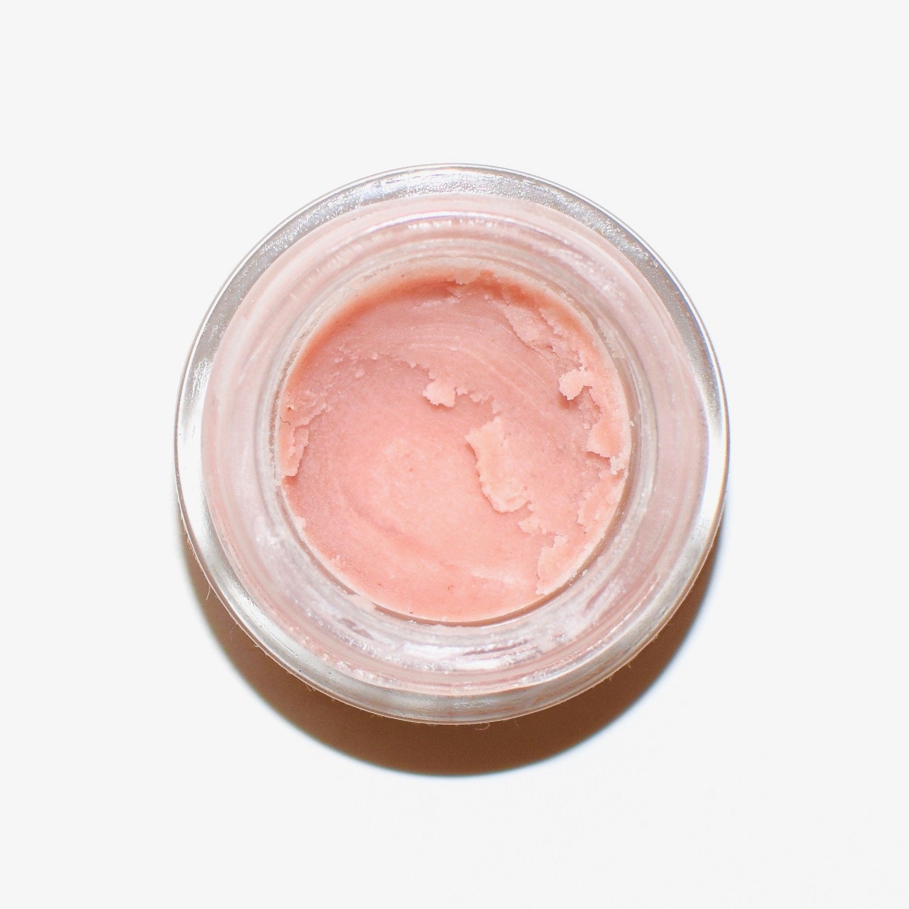 Plant Makeup Strawberry Dreamsicle Lip Balm Scrub in a clear jar with a pink and white creamy texture and fresh strawberry accents.