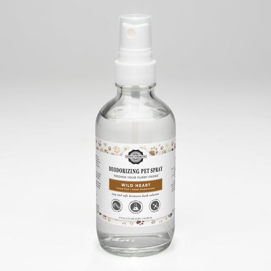 A clear spray bottle labeled Deodorizing Pet Spray | The Between-Wash Wonder by Rustic Strength with paw print designs, this sulfate-free spray features a white pump and is designed to freshen pets. The bottle sits on a plain white background.