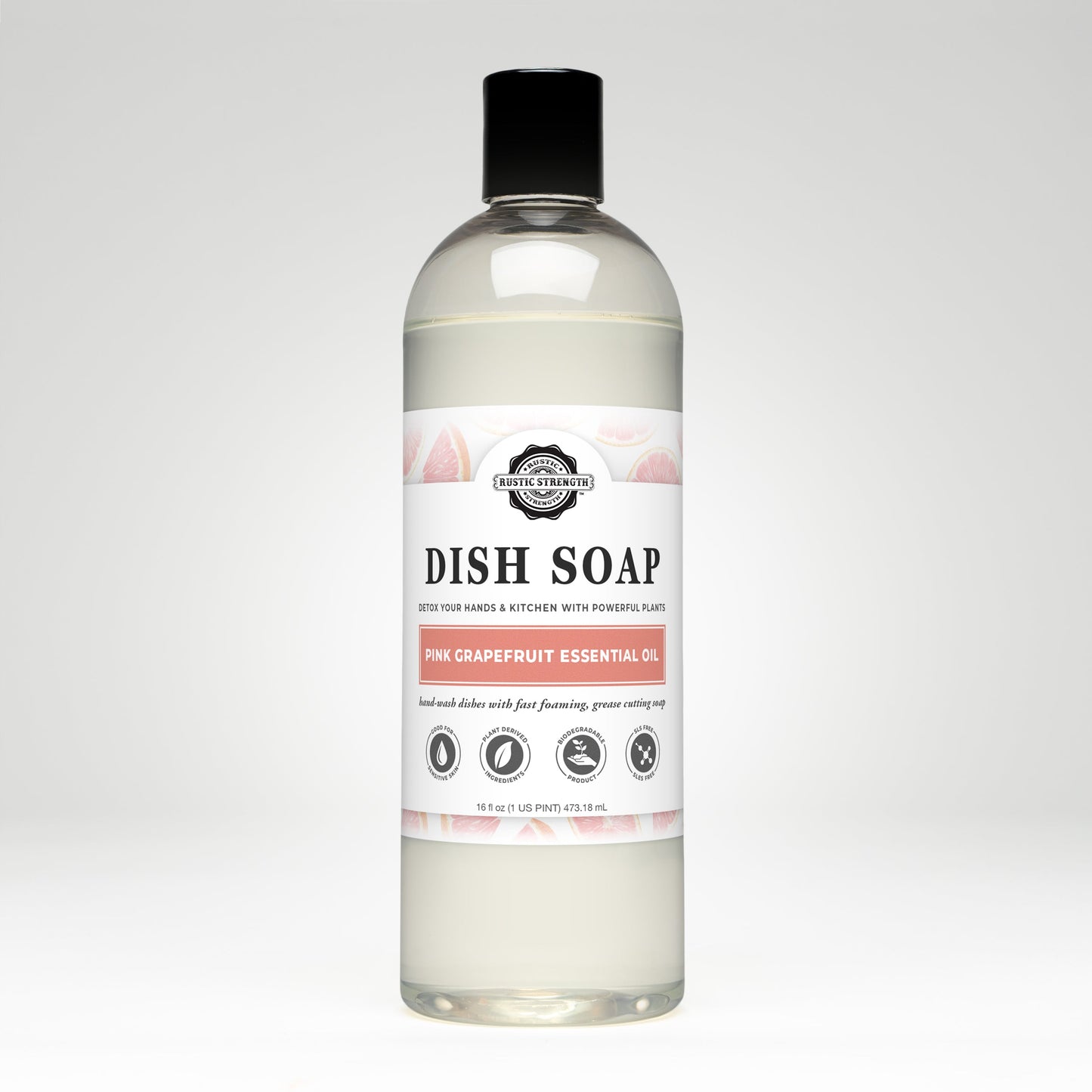 A clear bottle of Rustic Strength Dish Soap | Pink Grapefruit, biodegradable and scented with pink grapefruit essential oil, features a white label with grapefruit illustrations and black text, set against a plain white background.
