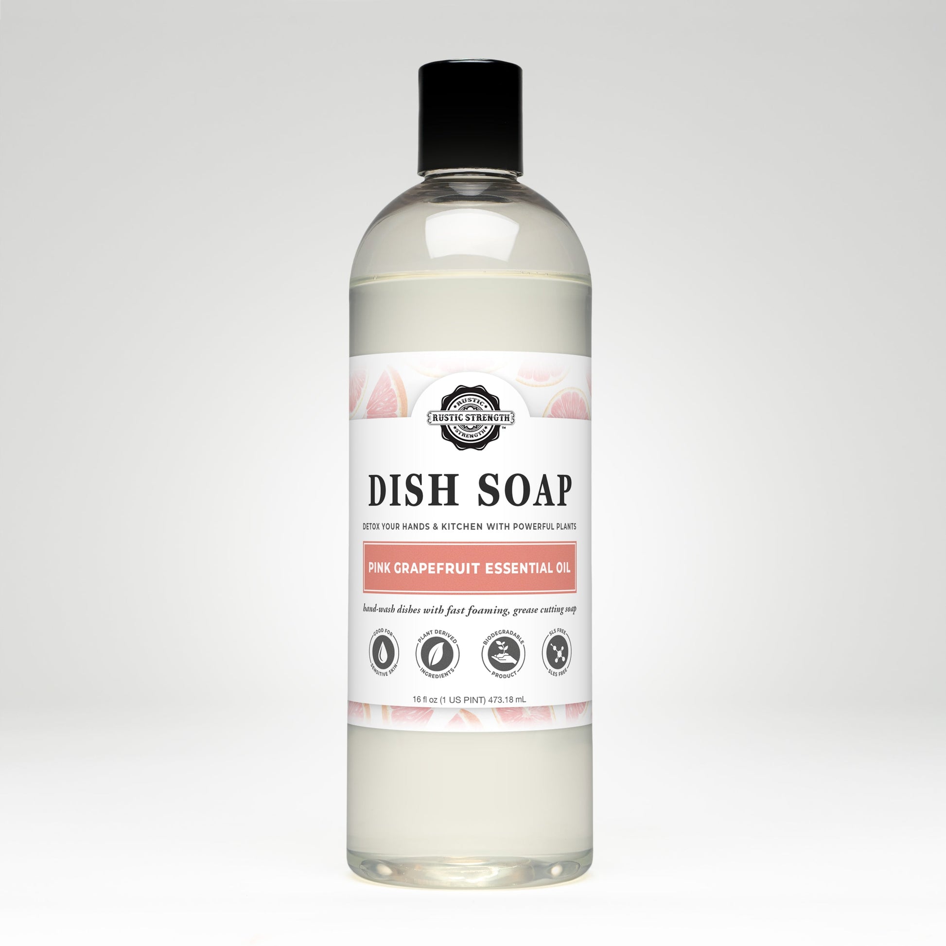 A clear bottle of Rustic Strength Dish Soap | Pink Grapefruit, biodegradable and scented with pink grapefruit essential oil, features a white label with grapefruit illustrations and black text, set against a plain white background.