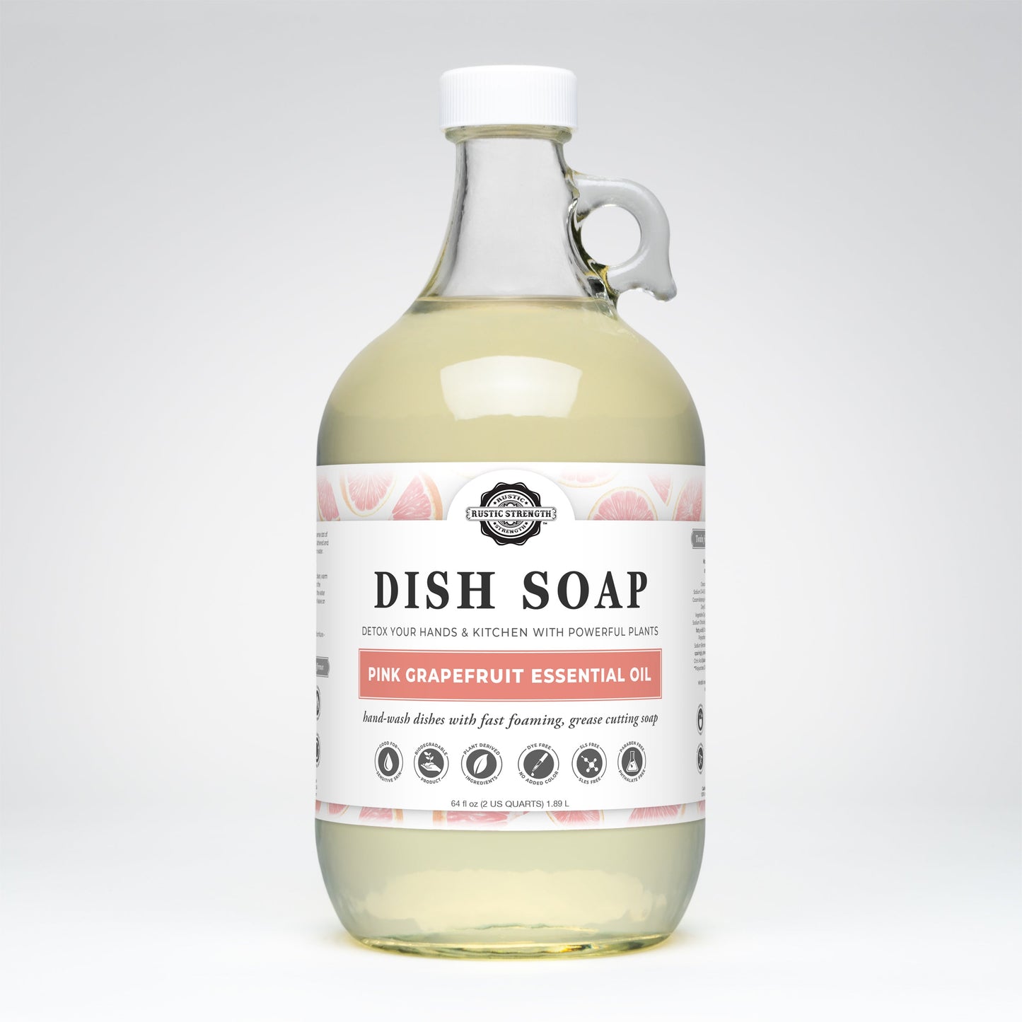Rustic Strength Dish Soap | Pink Grapefruit comes in a clear glass bottle with a loop handle, containing pale yellow, biodegradable liquid soap scented with essential oils. The label features grapefruit images and eco-friendly icons.
