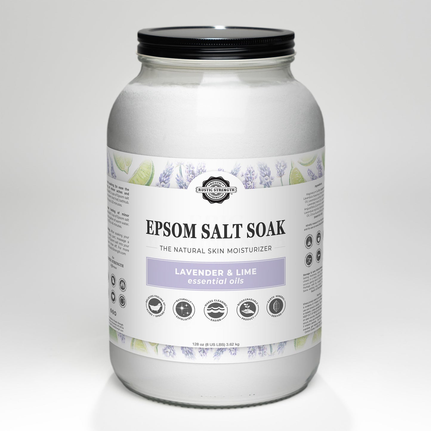 A large clear jar of Rustic Strength Epsom Salt Soak | Lavender & Lime with a black lid. The white label shows lavender and lime illustrations, lists essential oils, and describes this non-toxic blend for a relaxing experience.