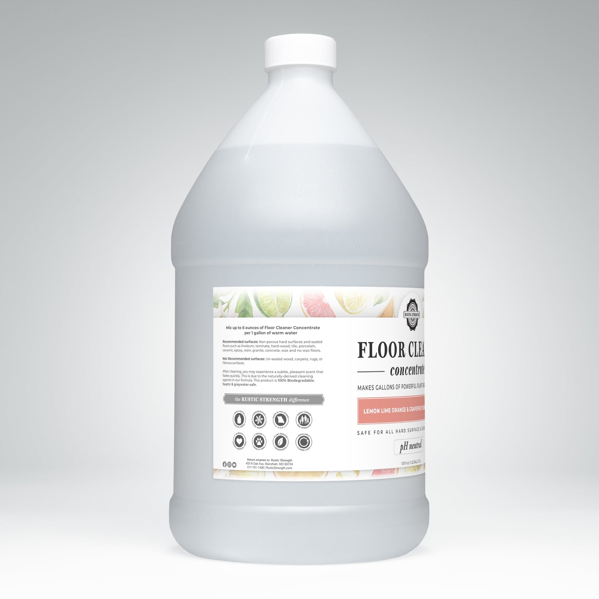 A large, translucent jug of Rustic Strength Floor Cleaner Concentrate—plant-based and non-toxic, with lemon, lime, orange & grapefruit scent—sits against a light gray background. The label displays details, icons, and a white cap.