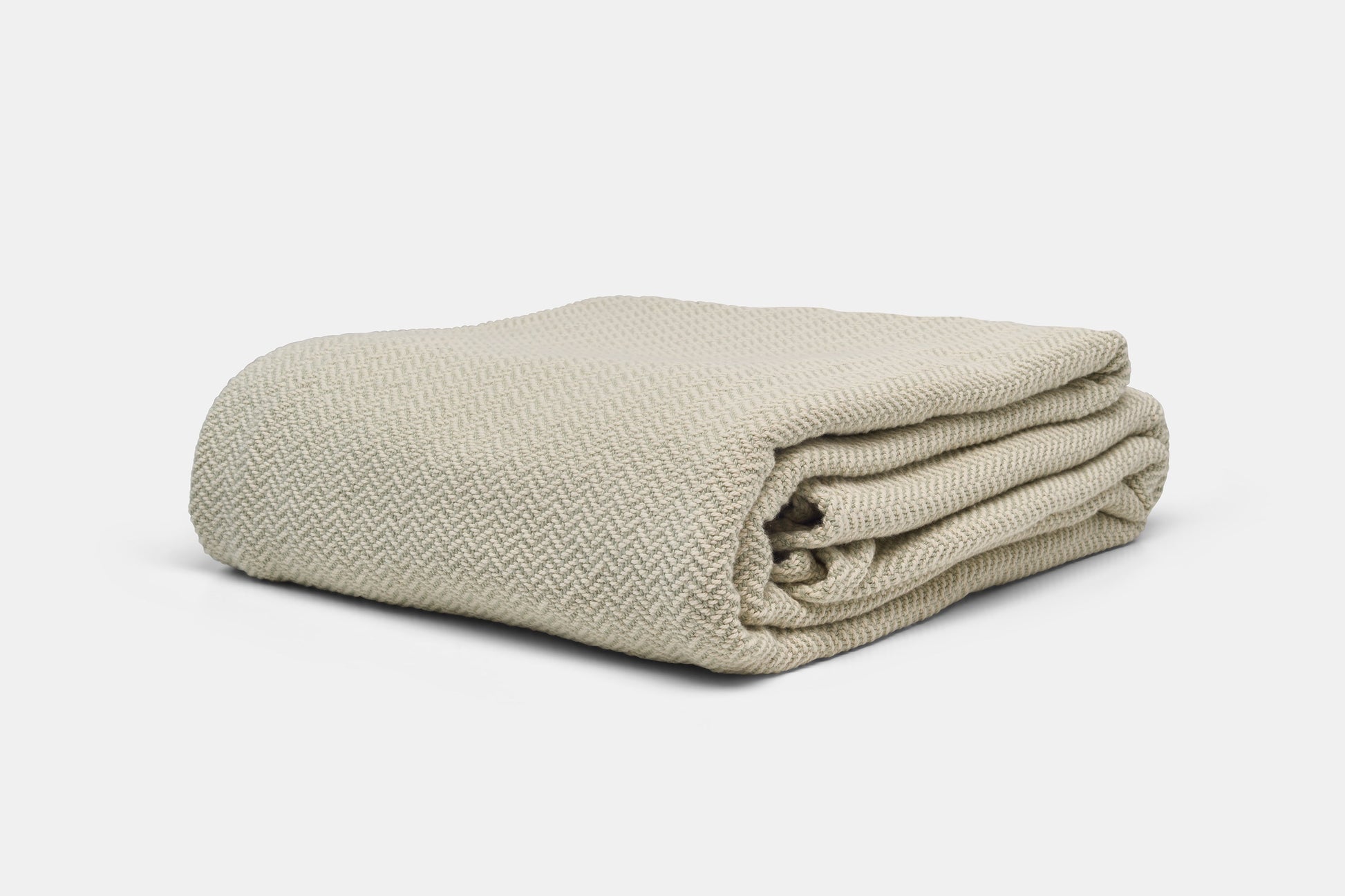 Green herringbone weave cotton blanket from American Blossom Linens, folded to show its soft, durable fabric. Made in the USA.