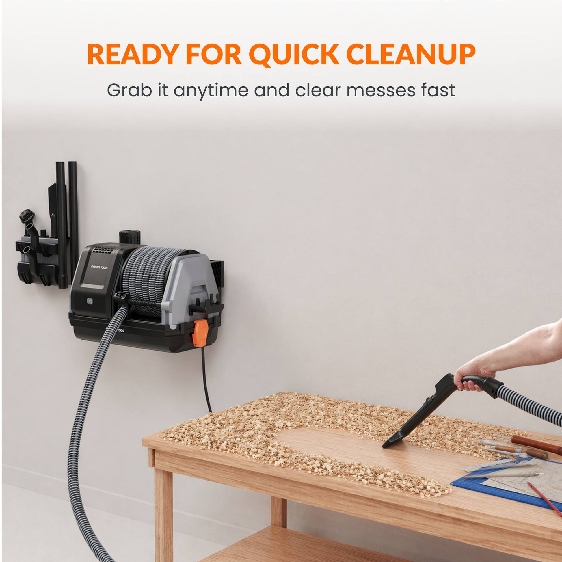 Giraffe Tools US Grandstorm retractable garage vacuum with hose and attachments, mounted on a garage wall for convenient cleaning.
