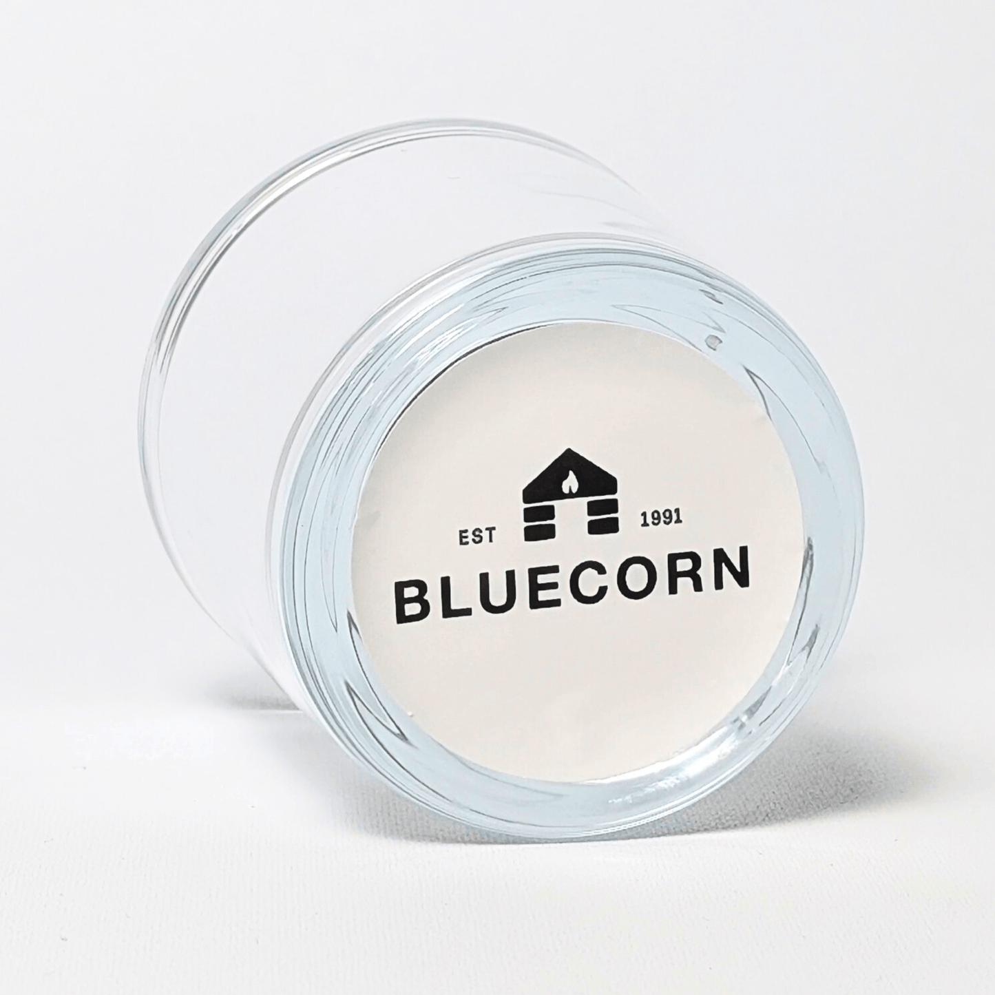 Bluecorn Candles heavy glass votive candle holder made from recycled glass, showcasing a clear, sturdy design with a sticker label.