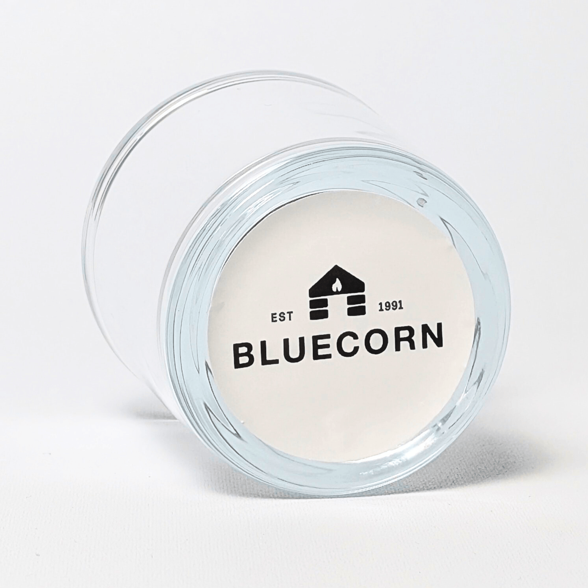 Bluecorn Candles heavy glass votive candle holder made from recycled glass, showcasing a clear, sturdy design with a sticker label.
