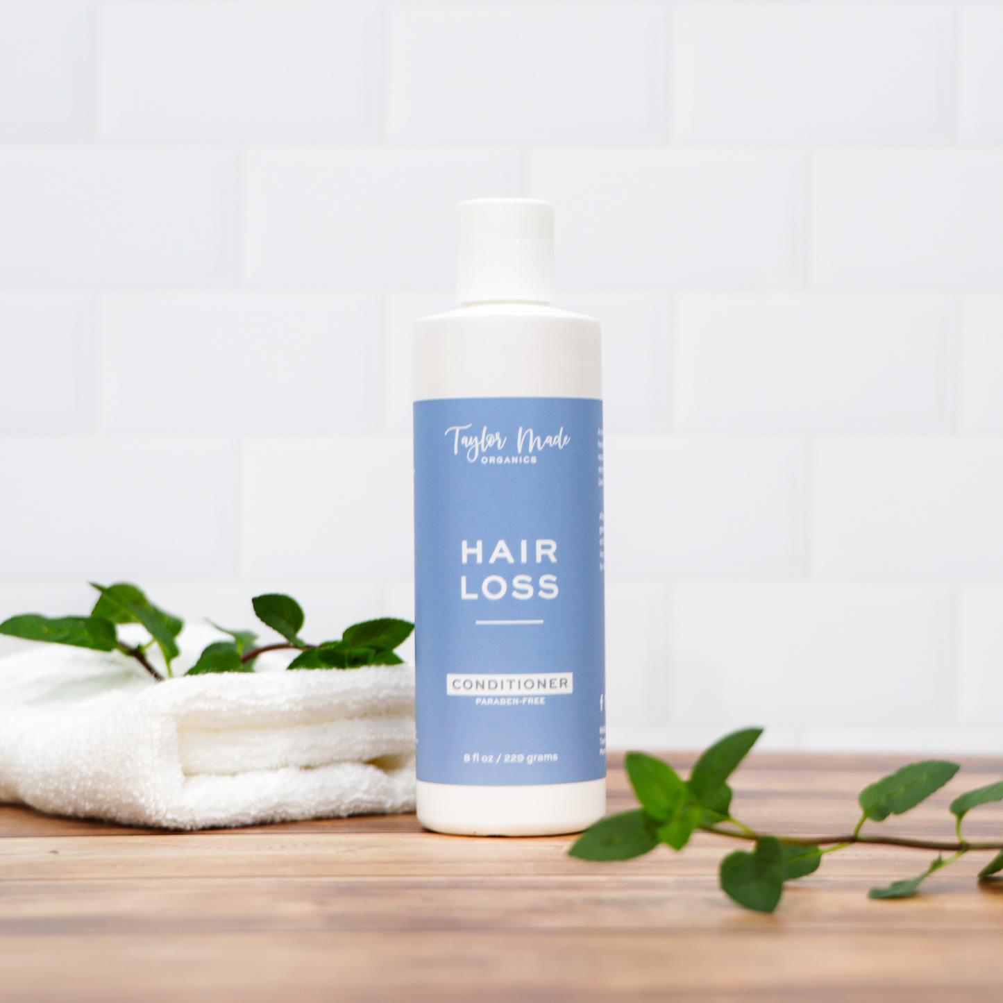 Organic hair loss conditioner with silk protein by Taylor Made Organics, featuring a bottle of nourishing hair care treatment.