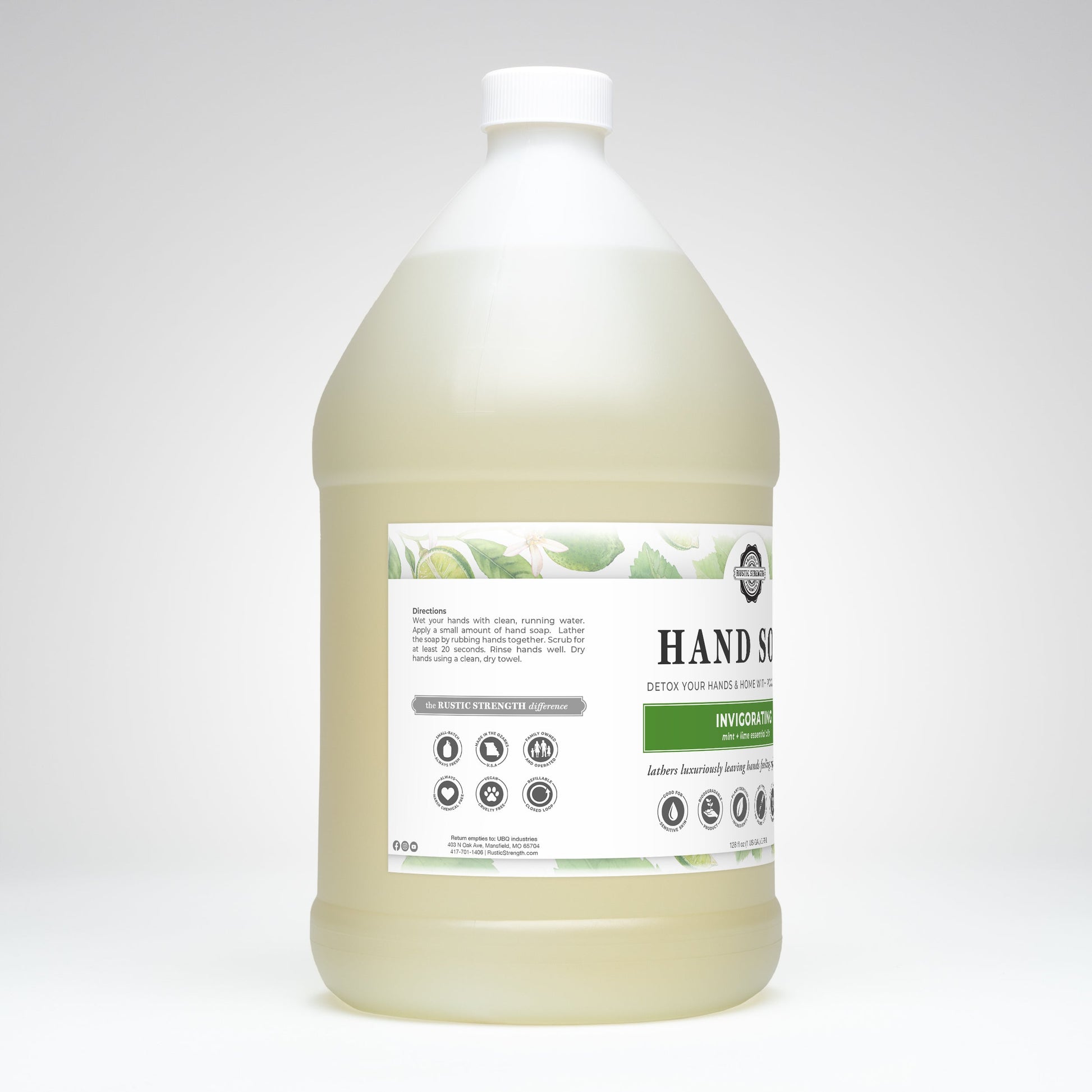 A large, clear gallon jug of Rustic Strength Hand Soap | Invigorating with a white cap. The label displays green leaves, highlights peppermint lime essential oil, and includes instructions and icons.