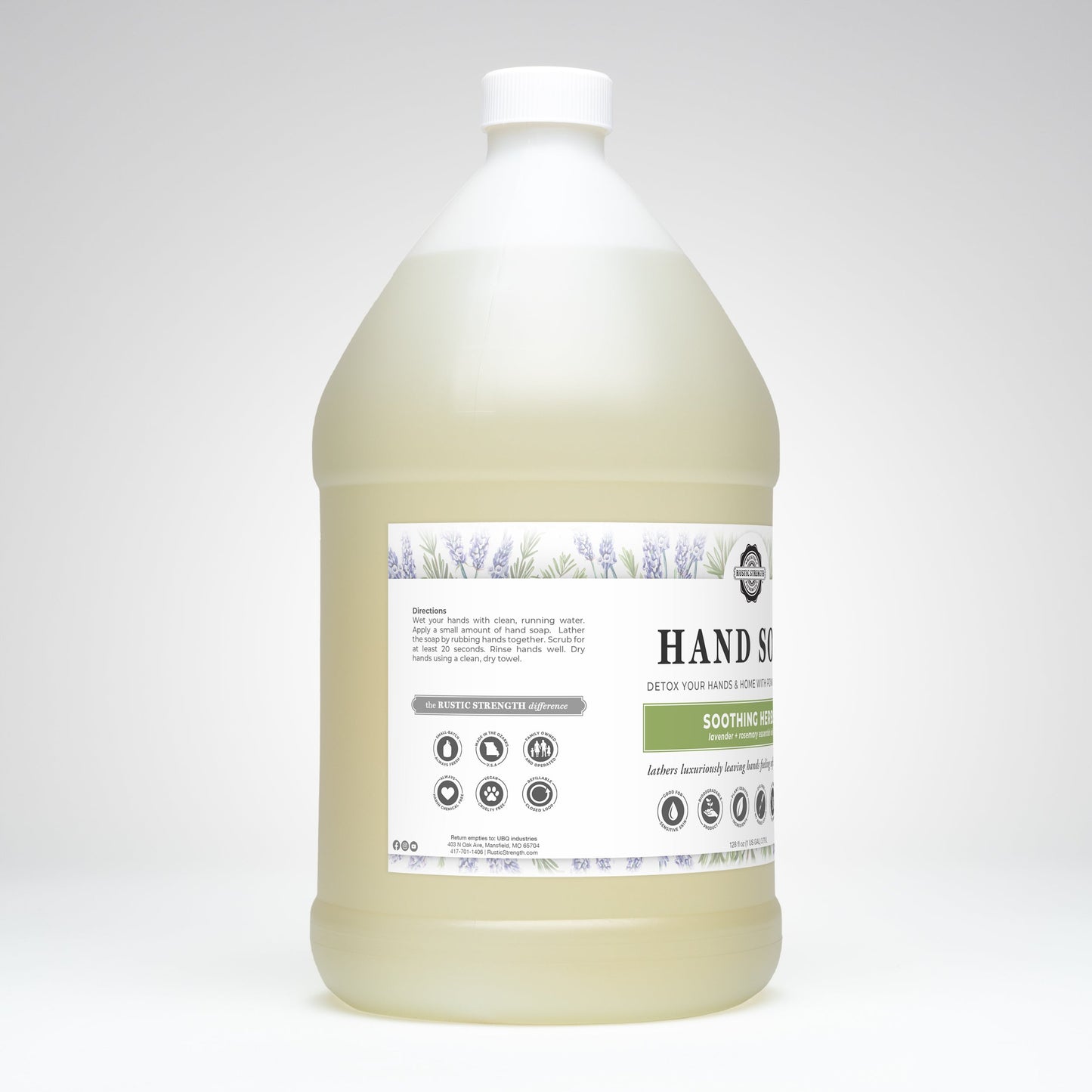 A large, clear plastic jug of pale yellow Rustic Strength Hand Soap | Soothing Herbs features lavender illustrations and highlights its biodegradable formula, directions, and ingredients on a white label.