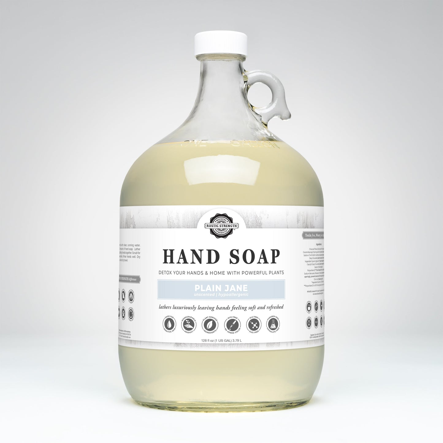 A large, clear gallon jug of Rustic Strength Hand Soap | Plain Jane sits against a white background. The label features black and white text with simple icons, and a small handle is near the neck. Hypoallergenic.