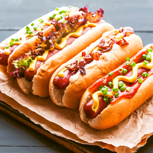 Jumbo grass-fed beef hot dogs from Pig of the Month BBQ topped with condiments and served in a bun.