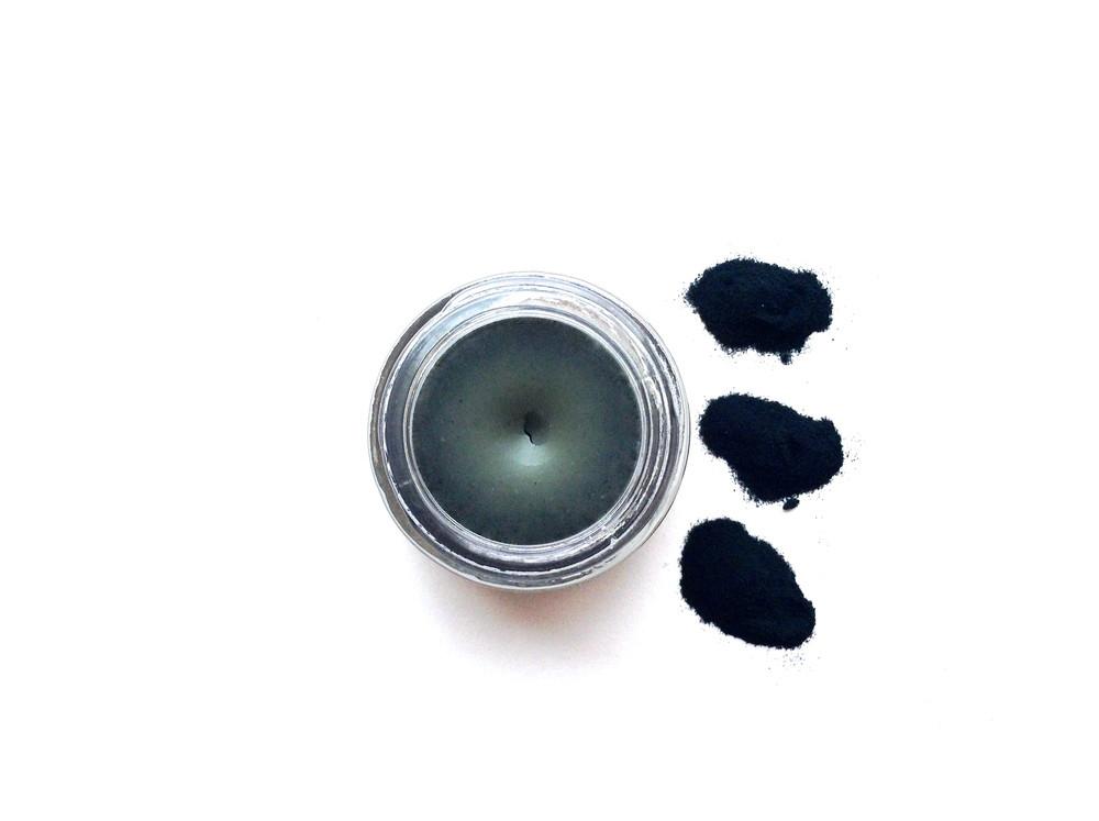 Mermaid makeup balm by plant makeup in a small jar with a shimmery, iridescent blue and green color, suitable for face and body.