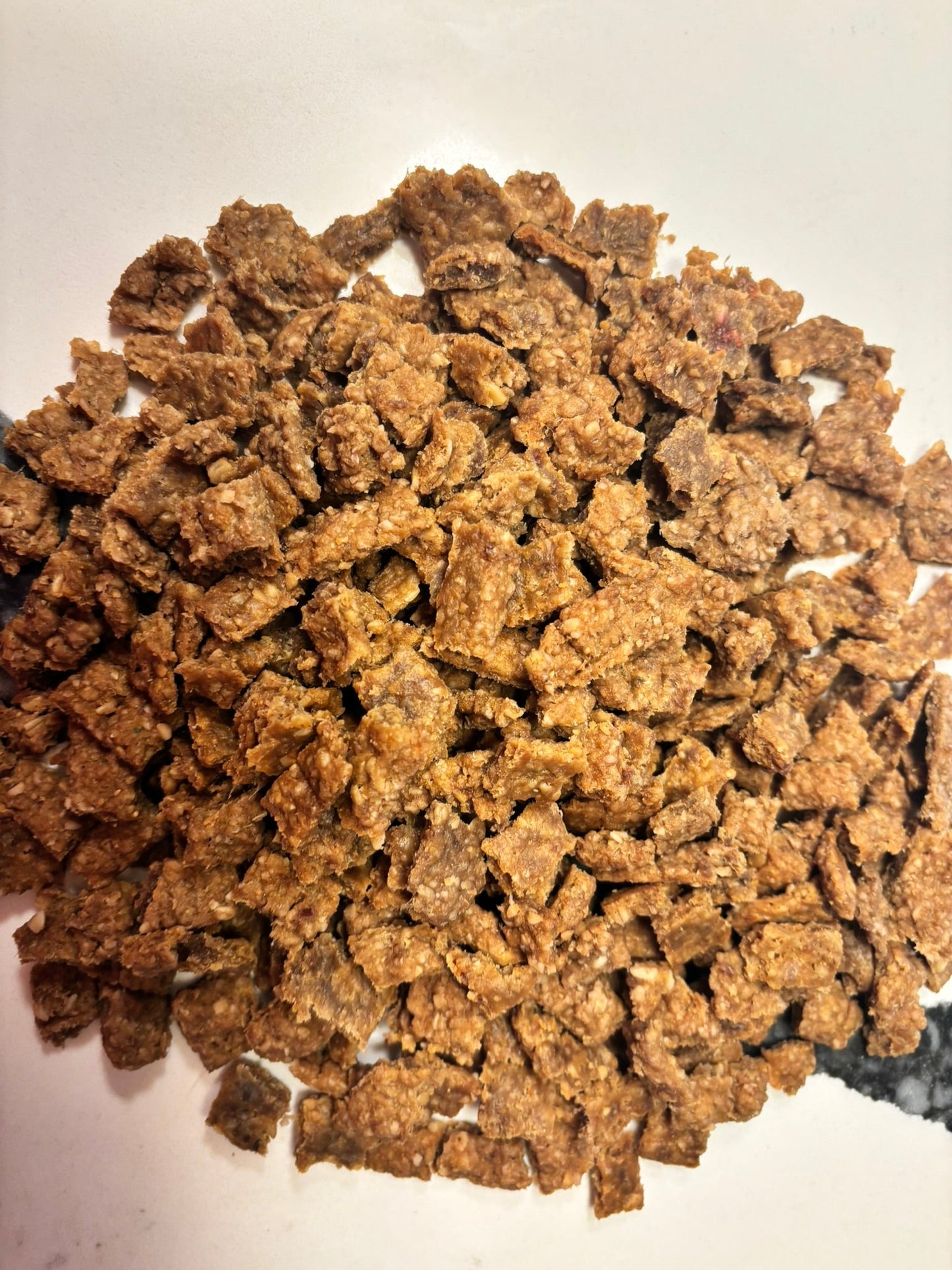 Organic beef training treats for dogs from PAWsitively Organic Dog Bakery, showing high-value, bite-sized dog treats on a white surface.