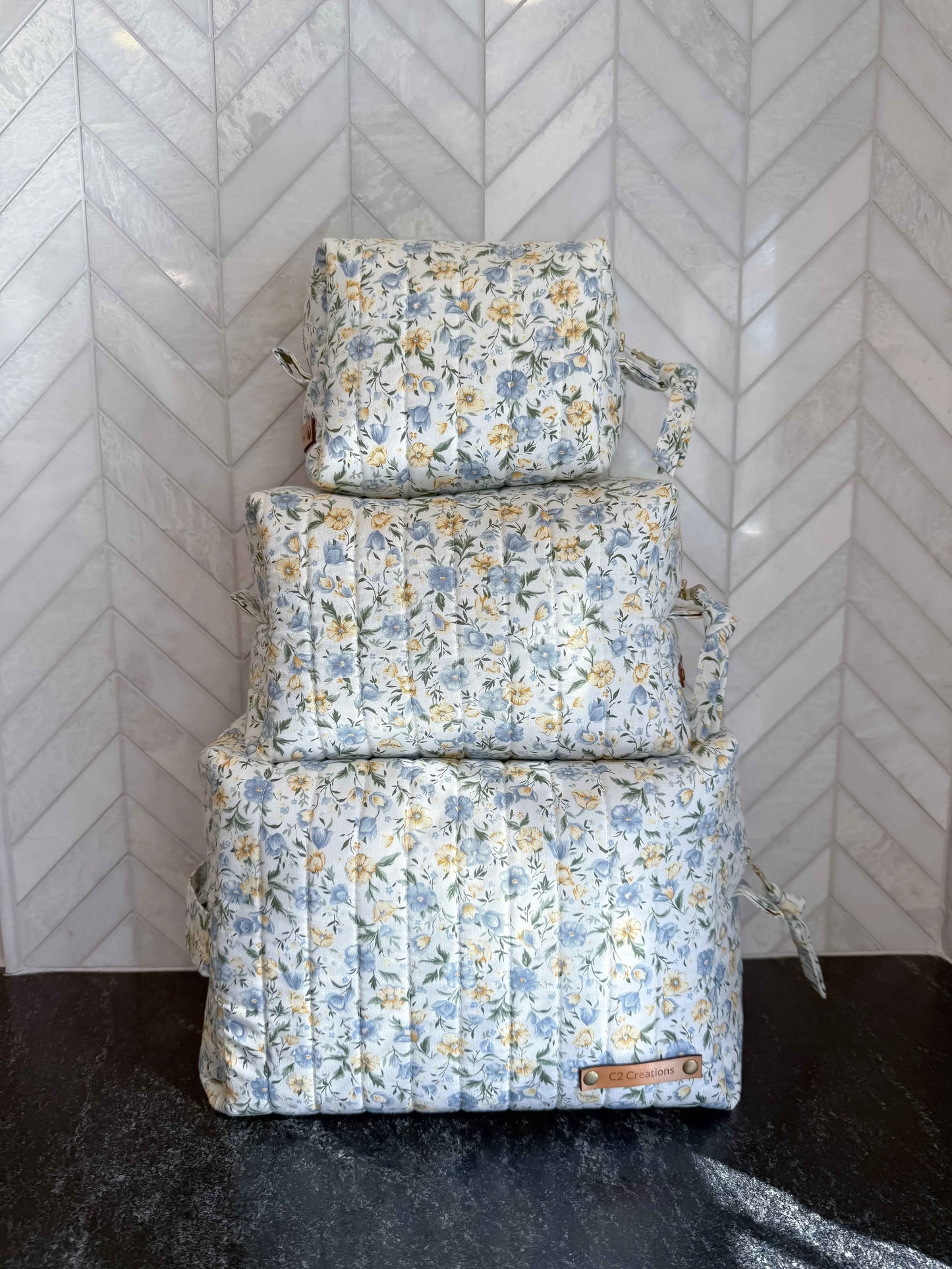 Handmade floral makeup bag with blue and yellow garden pattern by C2 Creations LLC, featuring a toiletry bag design.
