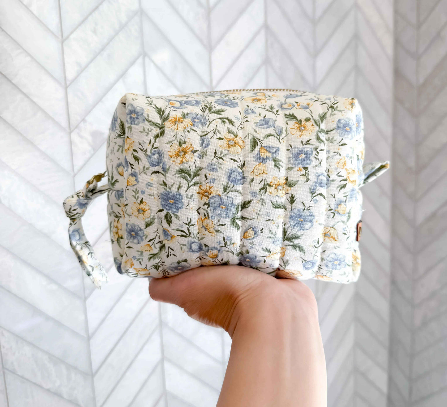 Handmade floral makeup bag by C2 Creations LLC featuring a blue and yellow garden pattern toiletry bag with zipper closure.