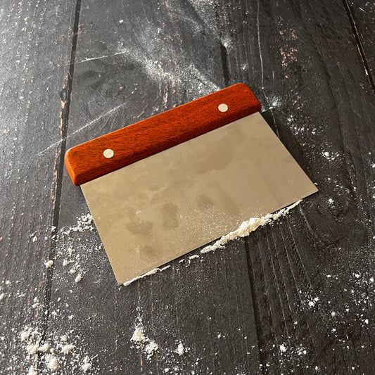 Farm-style bench scraper from Five Oaks Farm with a sturdy wooden handle and stainless steel blade for kitchen use.