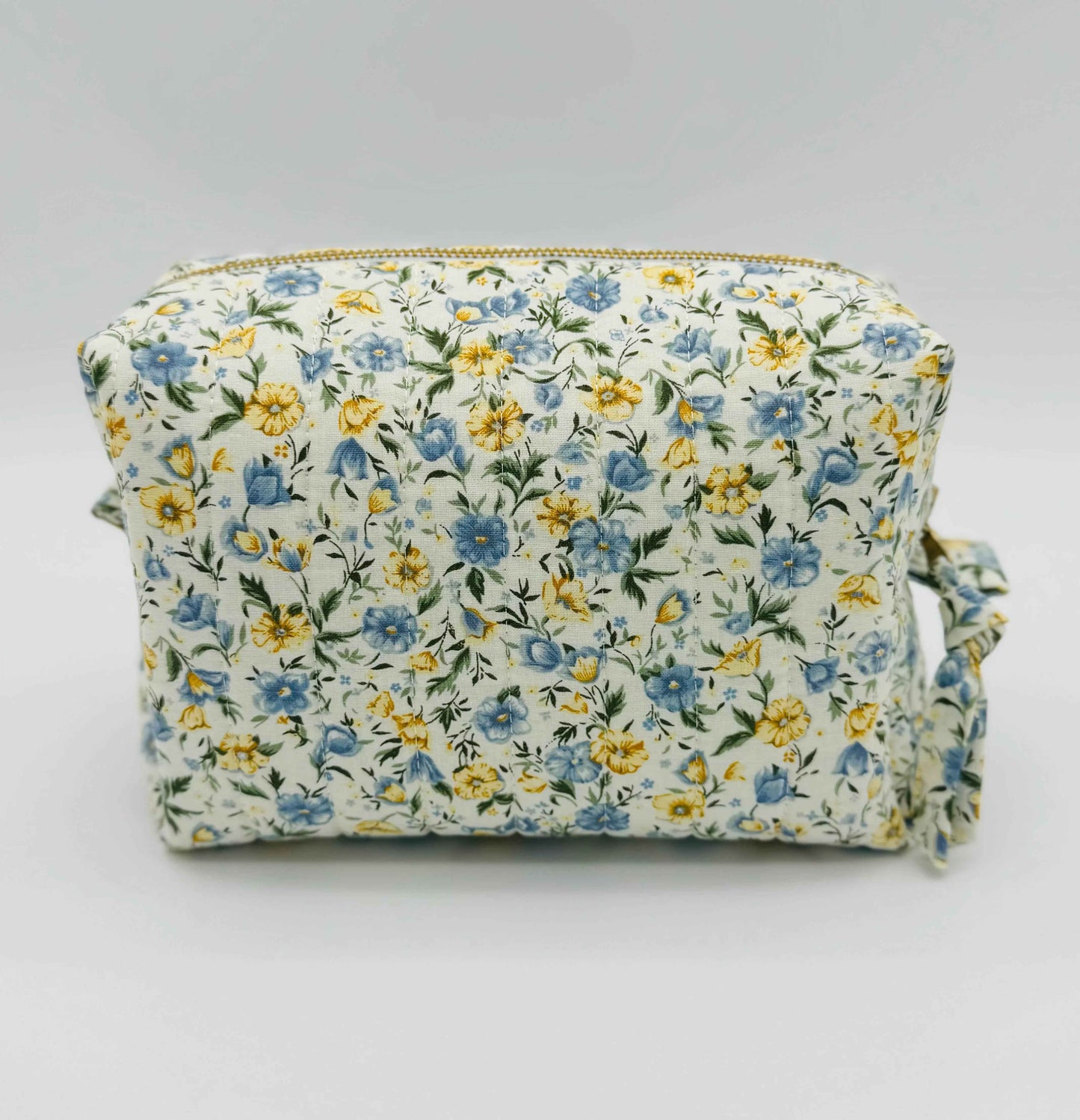 Handmade floral makeup bag by C2 Creations LLC with blue and yellow garden pattern, featuring a toiletry bag design.