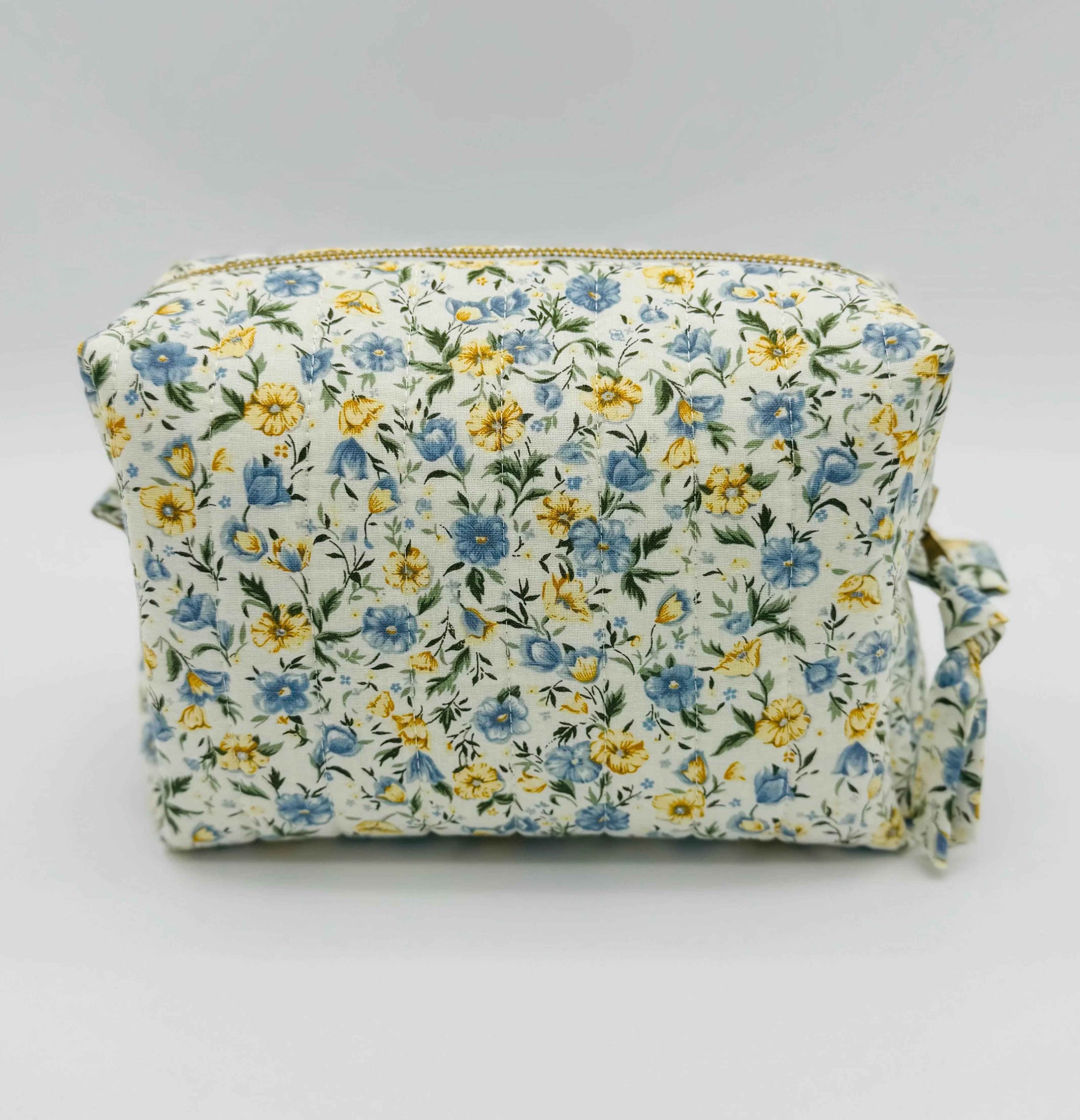 Handmade floral makeup bag by C2 Creations LLC with blue and yellow garden pattern, featuring a toiletry bag design.