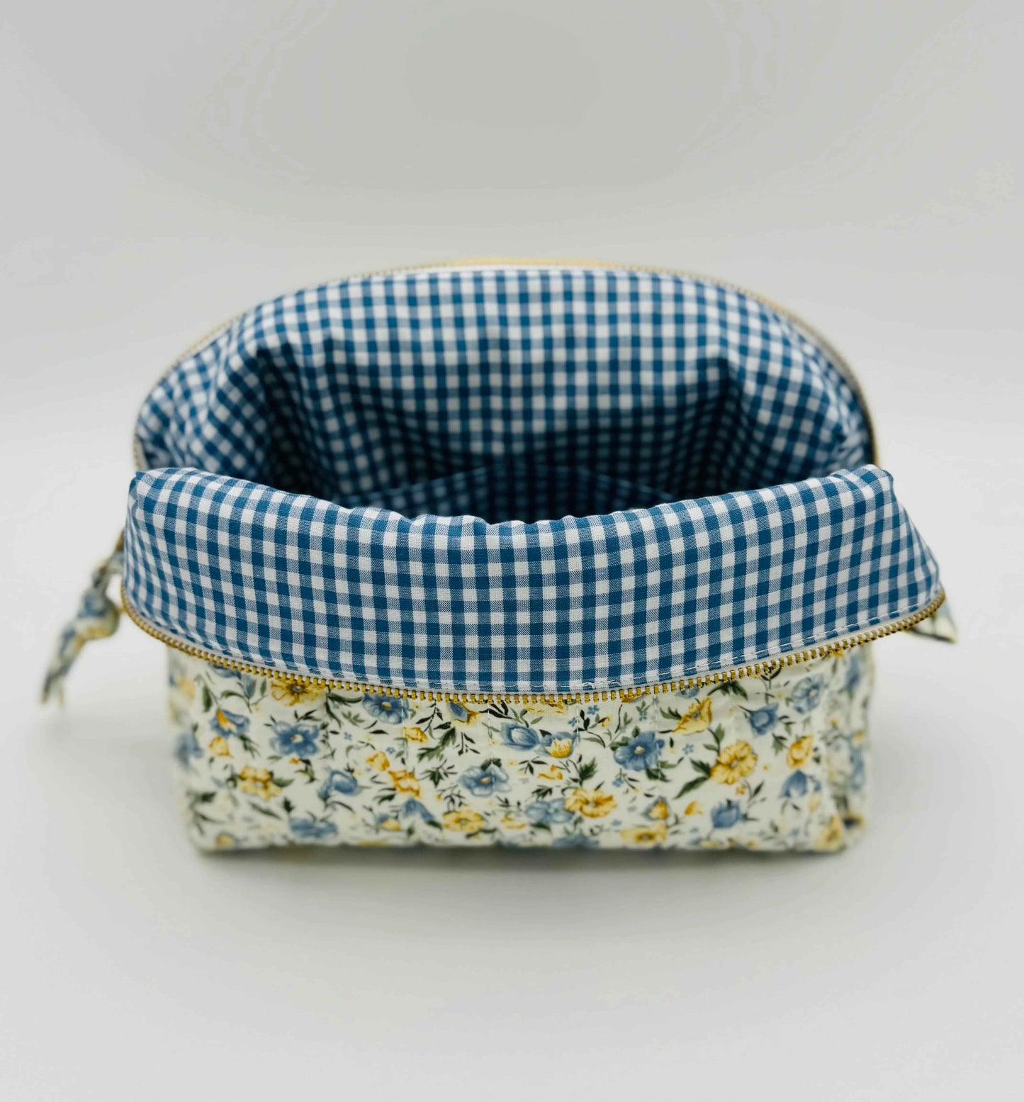 Handmade floral makeup bag in blue and yellow garden pattern by C2 Creations LLC, featuring a soft fabric toiletry bag.